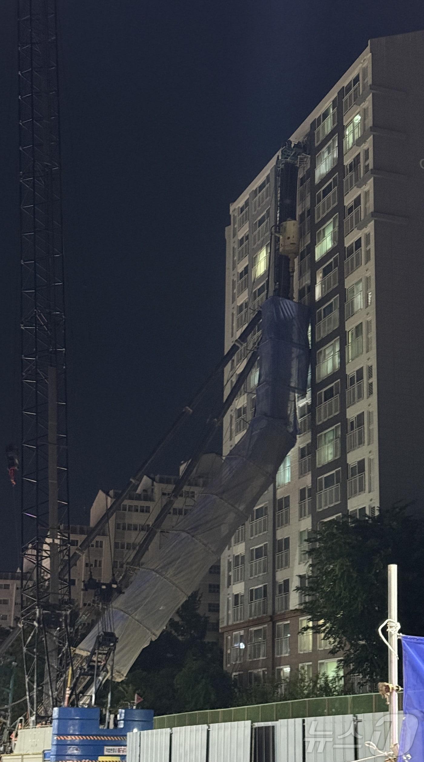 본문 이미지 - 5일 오후 10시 13분께 경기 용인시 기흥구 서천동 인덕원~동탄 복선전철 공사 현장에서 대형 중장비인 천공기(지반을 뚫는 건설기계)가 15층 높이 아파트를 덮친 모습. (독자 제공. 재판매 및 DB 금지) 2025.6.5/뉴스1 