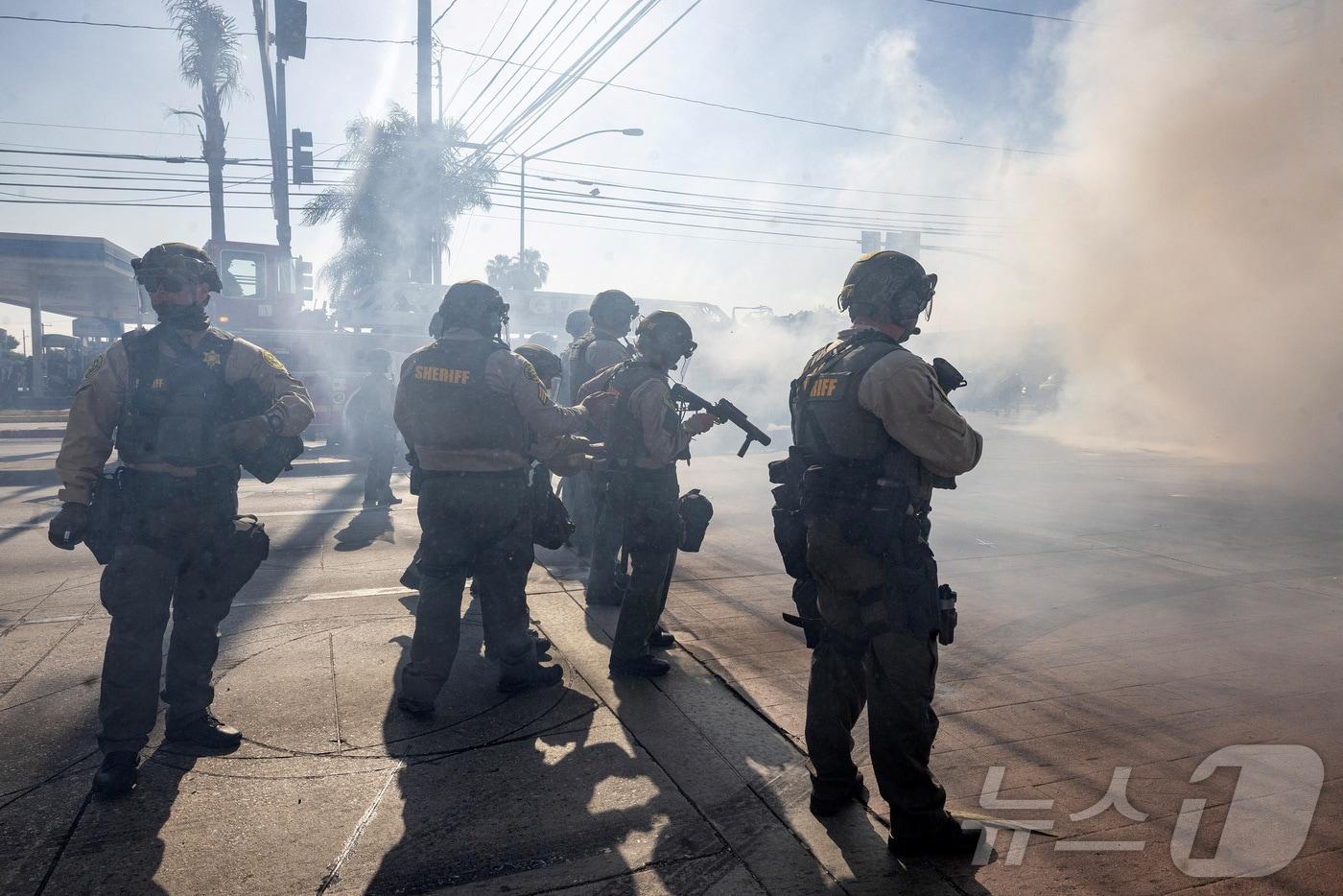 미국 로스앤젤레스 카운티에서 7일(현지시간) 미국 이민세관단속국(ICE)이 불법 체류 단속에 반발하는 시위대와 대치하고 있다. 2025.6.7. ⓒ 로이터=뉴스1