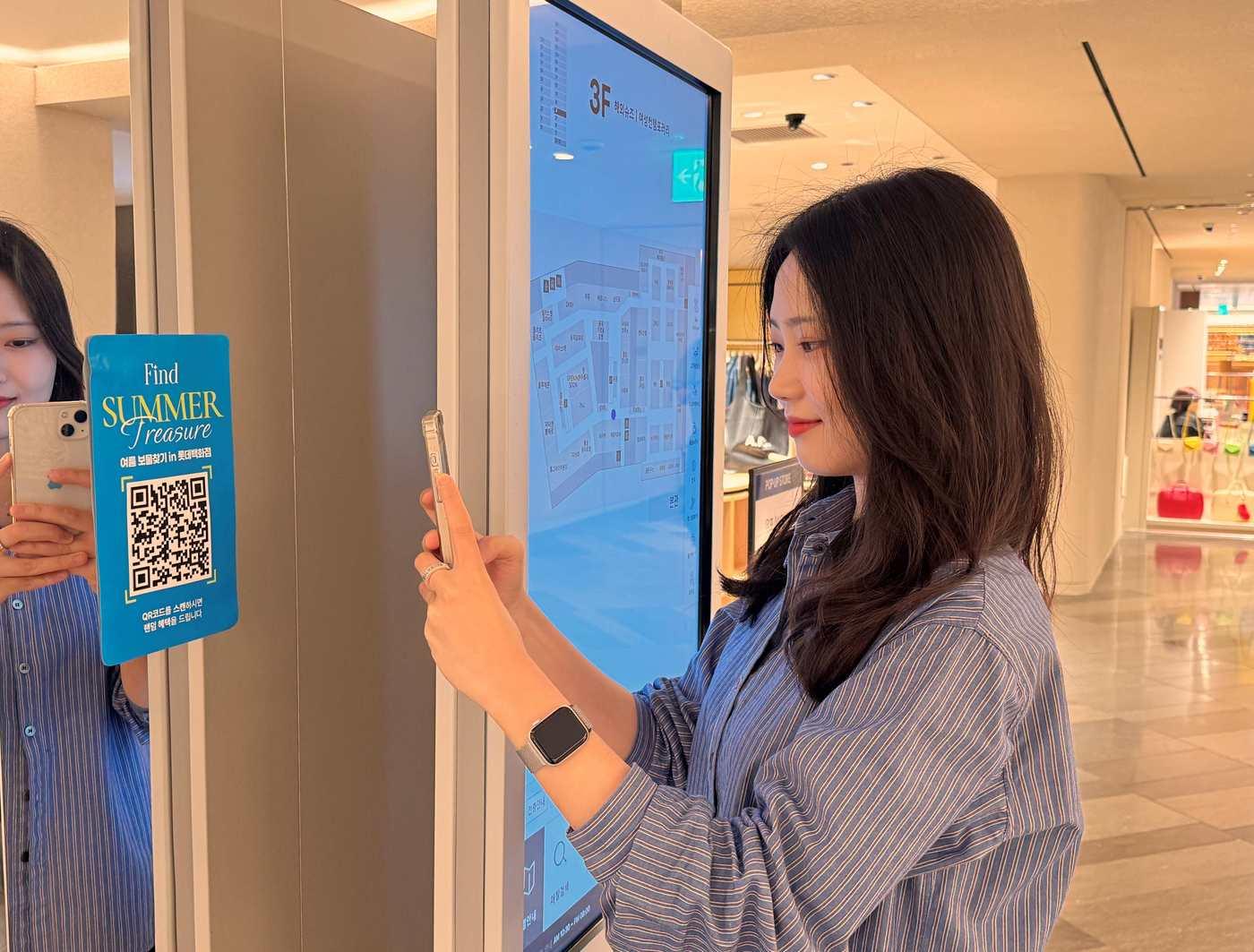 본문 이미지 - 롯데백화점 본점에서 한 고객이 'QR 보물찾기'를 체험하고 있다(롯데백화점 제공).