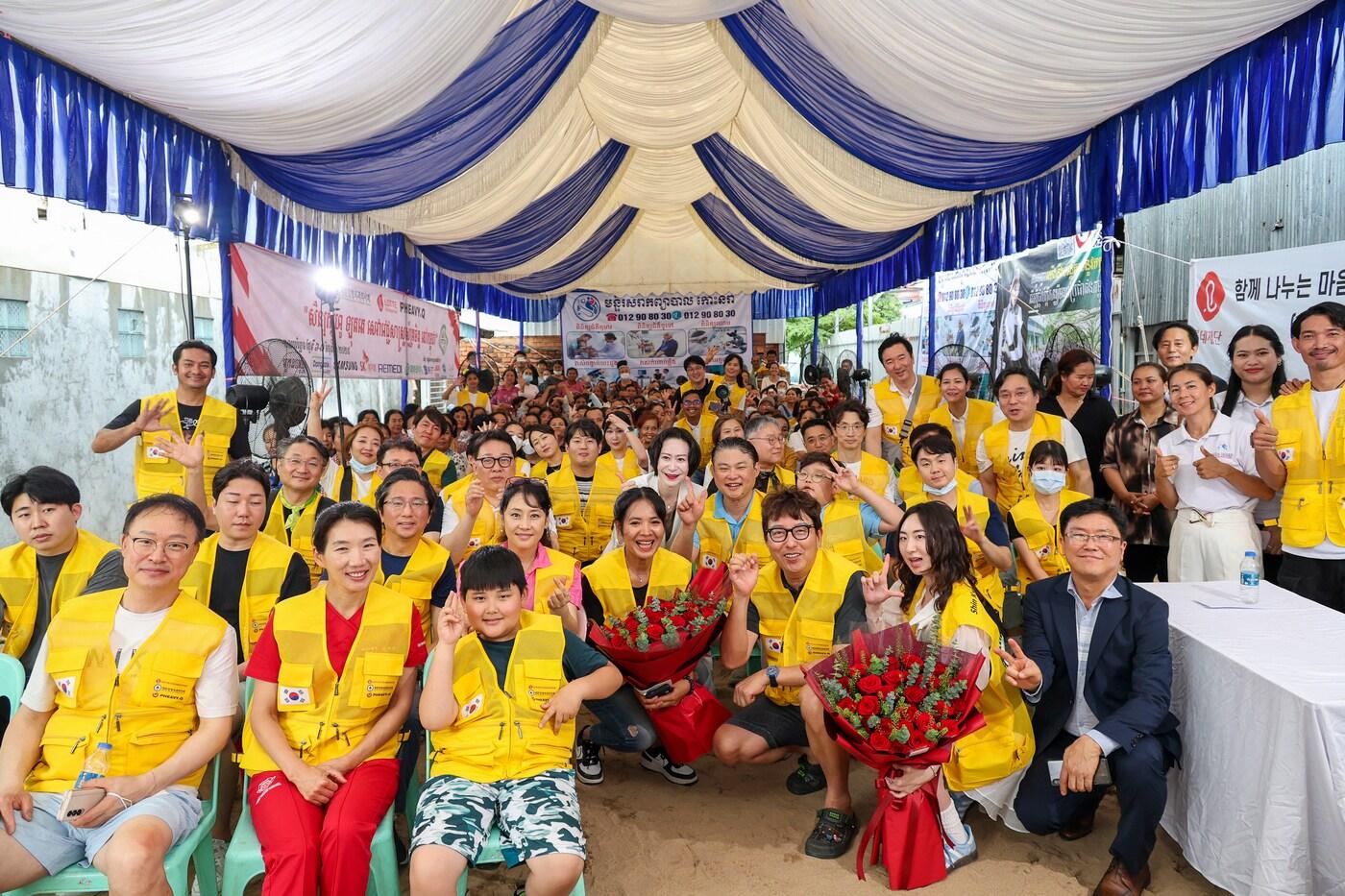 장혜선 롯데장학재단 이사장(세 번째 줄 가운데), 김완호 대한정형외과의사회 회장(두 번째 줄 여섯 번째), 피아비한캄사랑재단 스롱 피아비 대표이사(두 번째 줄 다섯 번째) 및 의료진들과 봉사 관계자, 캄보디아 현지 주민들이 함께 기념사진을 촬영하고 있다.(롯데장학재단 제공). 