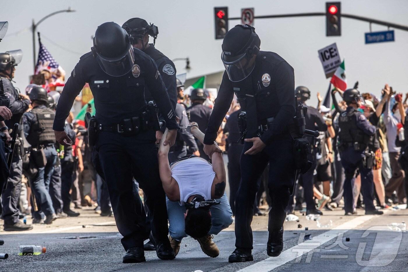 8일(현지시간) 미국 LA에서 경찰이 시위대를 체포하고 있다. ⓒ AFP=뉴스1