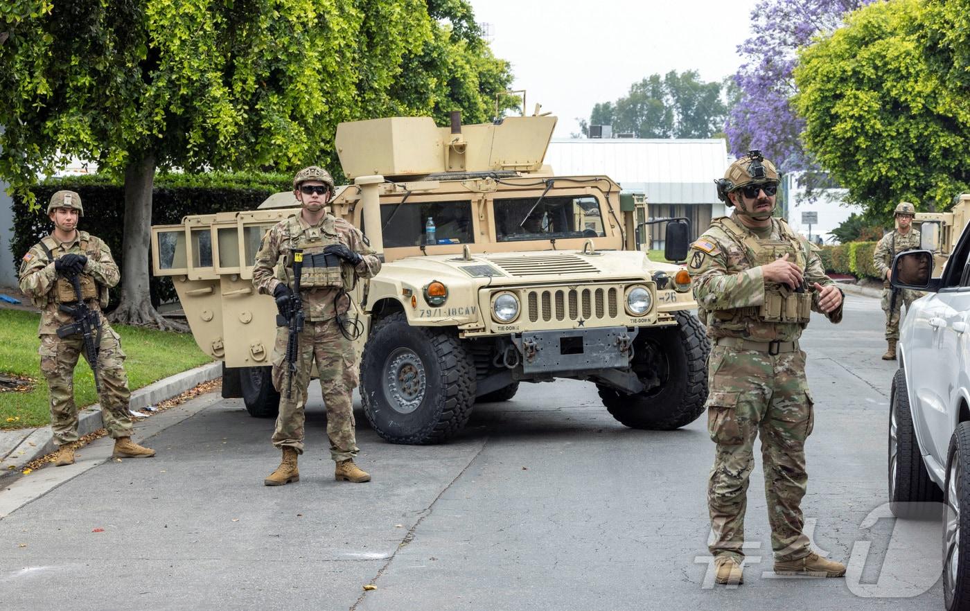 8일&#40;현지시간&#41; 미국 캘리포니아 주방위군이 로스앤젤레스&#40;LA&#41;의 패러마운트 비즈니스 센터 주차장에서 경계근무를 서고 있다. LA에서는 도널드 트럼프 행정부의 불법이민 단속에 항의하는 시위가 사흘째 이어지고 있는 가운데, 트럼프 대통령은 시위 진압을 위해 7일 이례적으로 주방위군 2000명 투입을 명령하면서 시위 양상이 더욱 격화되고 있다. 2025.06.08 ⓒ 로이터=뉴스1 ⓒ News1 김지완 기자