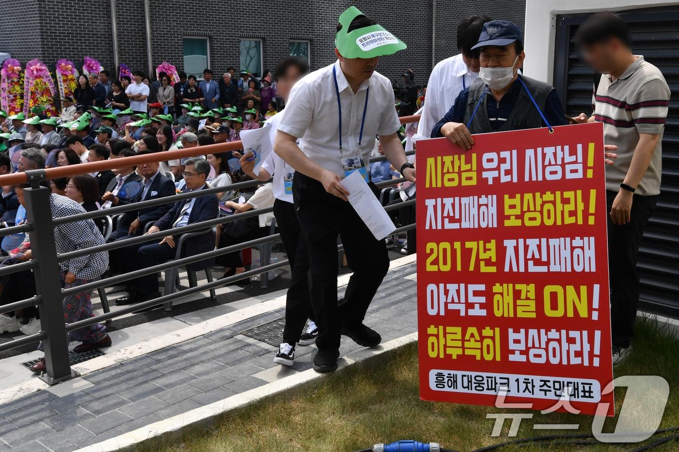 9일 경북 포항시 북구 흥해읍에서 열린 북구보건소와 트라우마 개소식에서 '포항 촉발지진' 피해자가 보상 촉구 1인 시위를 하고 있다. 2025.6.9/뉴스1 ⓒ News1 최창호 기자