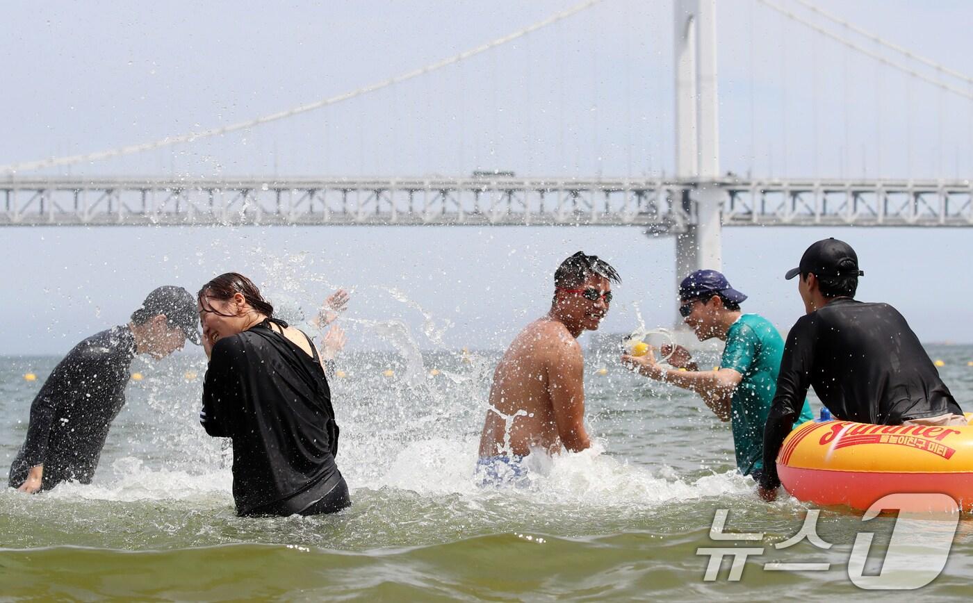 무더위가 기승을 부린 1일 개장한 부산 수영구 광안리해수욕장을 찾은 관광객들이 물놀이를 즐기며 더위를 식히고 있다.2025.7.1/뉴스1 ⓒ News1 윤일지 기자