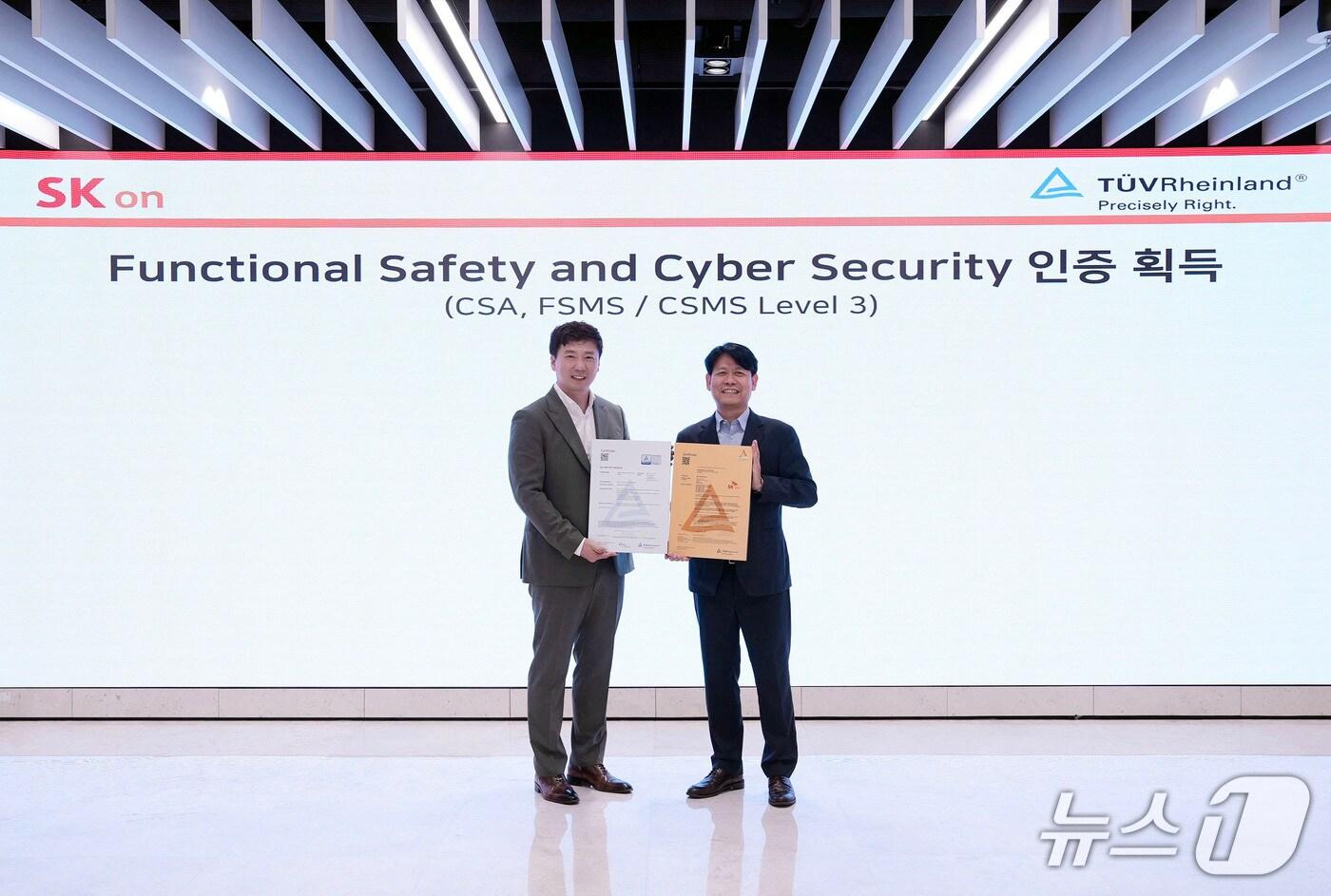박기수 SK온 연구개발(R&D) 본부장(오른쪽)과 노진표 TUV라인란드 코리아 기능 안전 및 사이버 보안 아시아 총괄 이사가 9일 오후 대전 SK온 배터리 연구원에서 사이버 보안 인증(CSA) 등 국제 인증 수여식 행사 후 기념 촬영을 하고 있다.(SK온 제공) 