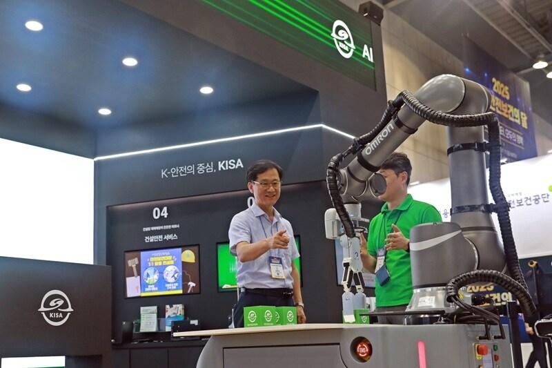 본문 이미지 - 대한산업안전협회는 7월 7일부터 10일까지 ‘스마트안전보건전시회’에 참여해 홍보 부스를 운영하고 있다. 임무송 협회장이 산업용 로봇의 협동 운동 기능 중 속도 및 위치 감시 기능을 확인하고 있는 모습 / 사진=대한산업안전협회 제공