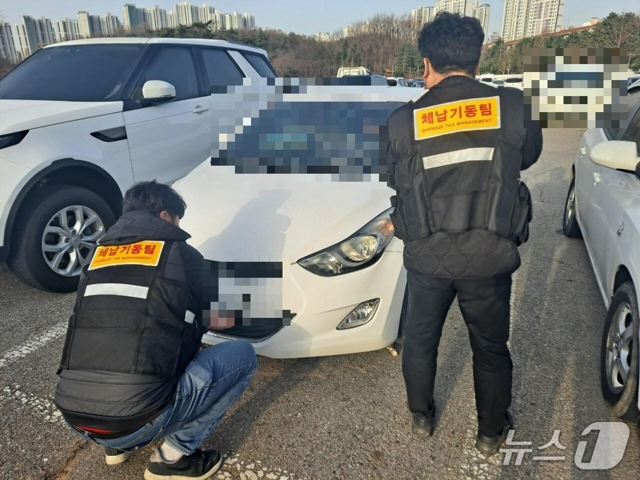 본문 이미지 - 안산시 체납기동팀이 체납차량에 대한 번호판 영치 작업을 진행하고 있다.(안산시 제공)