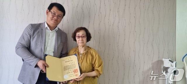 본문 이미지 -  서승일 대전보훈청장과 고(故) 박광삼 무공수훈자 유족이 유공자 증서를 들어보이고 있다.(대전보훈청 제공 /뉴스1