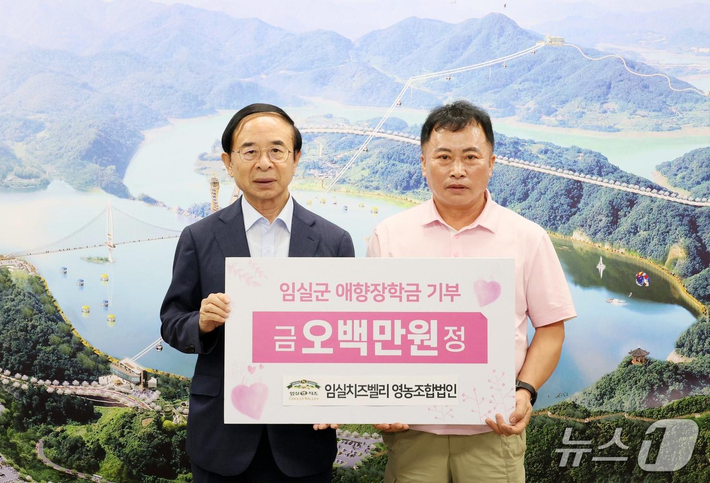 김인호 치즈벨리영농조합법인 전무이사(오른쪽)가 심민 임실군수에게 장학금 500만원을 기탁하고 있다.(임실군제공. 재판매 및 DB금지)2025.7.10/뉴스1