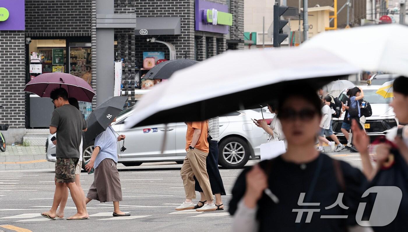 서울 종로구 거리에서 시민들이 우산을 쓴 채 거리를 거닐고 있다. 2025.7.13/뉴스1 ⓒ News1 김성진 기자