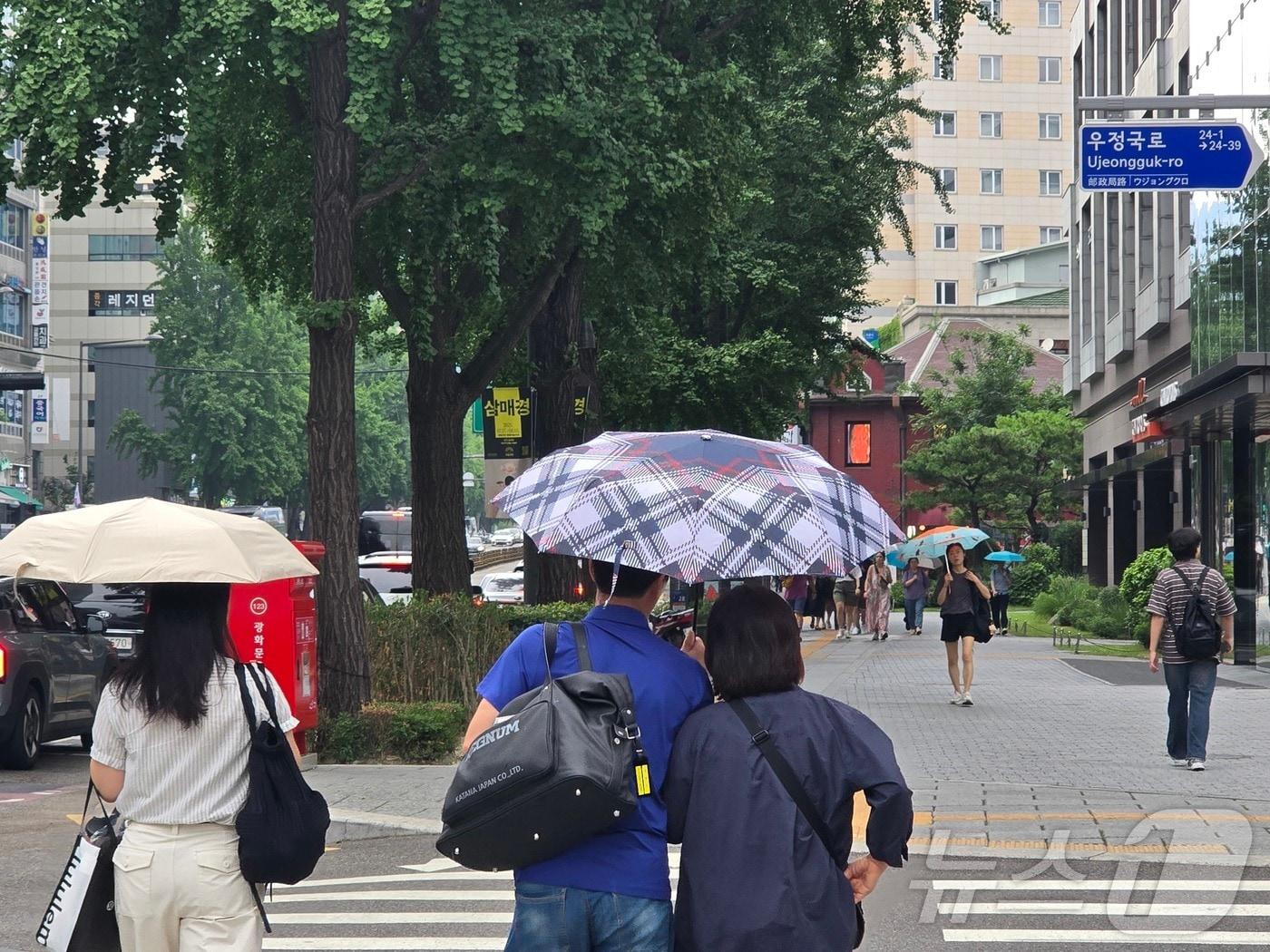 본문 이미지 - 13일 서울 종로구 종각역 인근에 비가 내리며 무더위를 식히고 있다. 시민들이 우산을 쓰고 길을 거닐고 있다. 2025.7.13/뉴스1 ⓒ News1 황덕현 기후환경전문기자