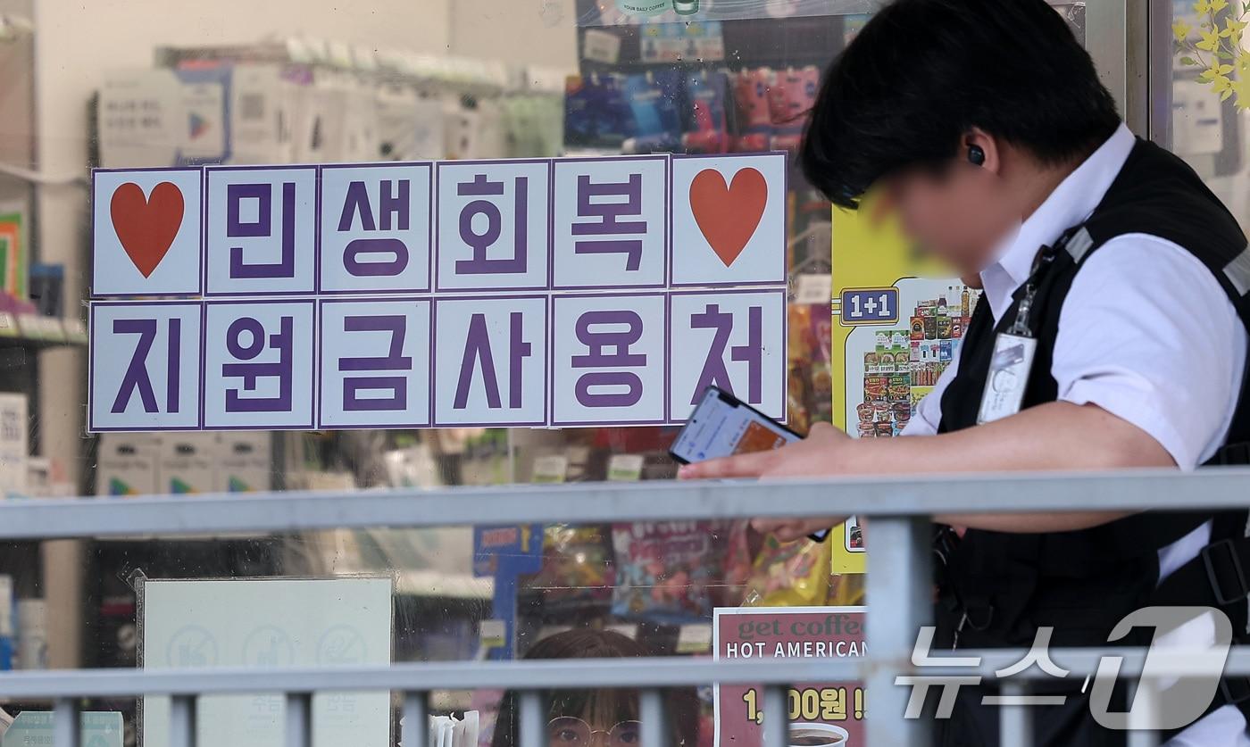 행정안전부가 민생회복 소비쿠폰 신청을 앞두고 국민비서를 통해 지급금액과 신청방법 등 정보를 사전 안내하는 서비스를 14일부터 시작한다.  사진은 13일 서울 시내 한 편의점에 게시된 민생회복 지원금 사용 관련 안내문. 2025.7.13/뉴스1 ⓒ News1 김성진 기자