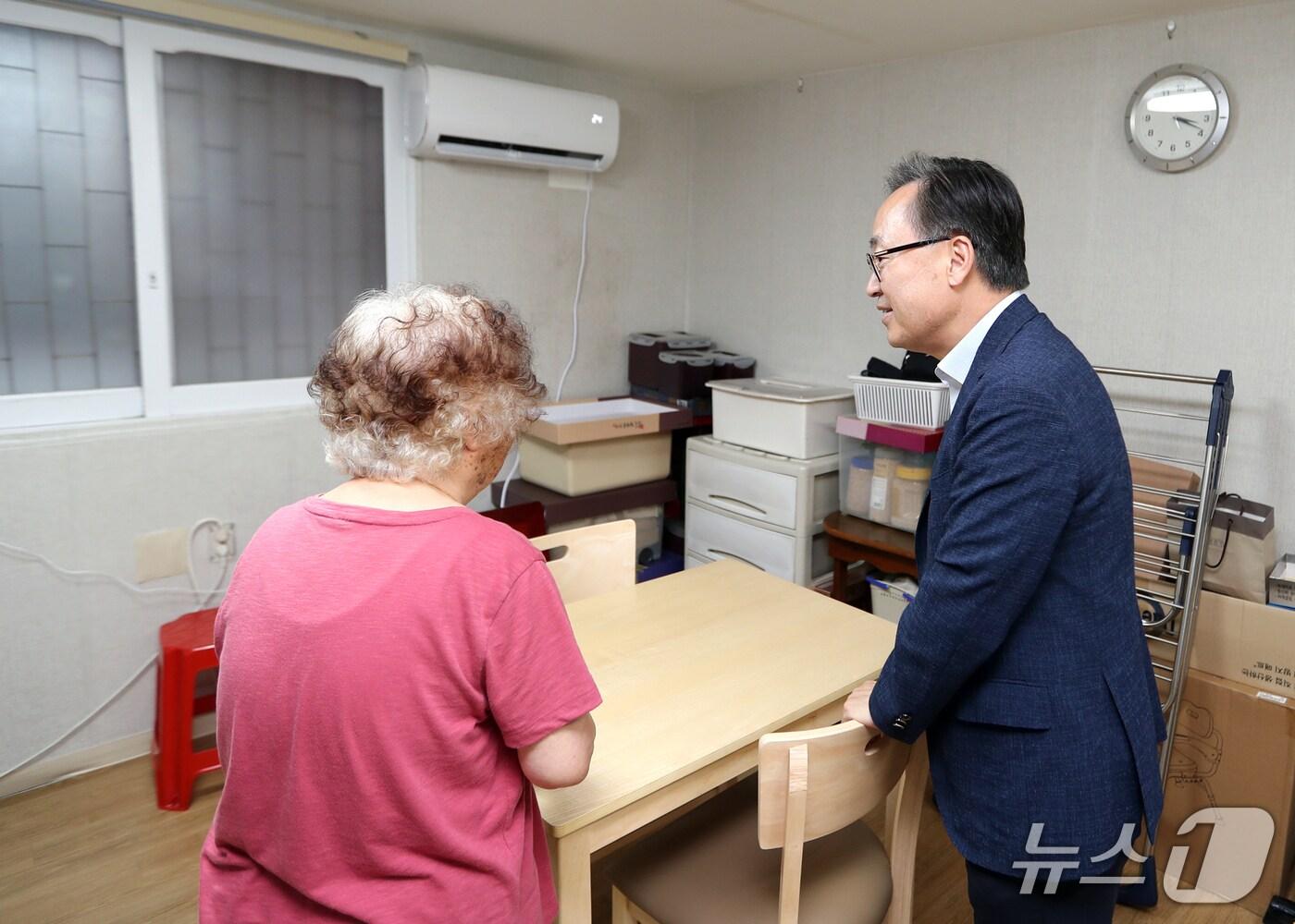 본문 이미지 - 유성훈 금천구청장이 에어컨 설치 지원을 받은 취약계층 가구를 방문하여 안부를 살피고 있다.(금천구 제공)