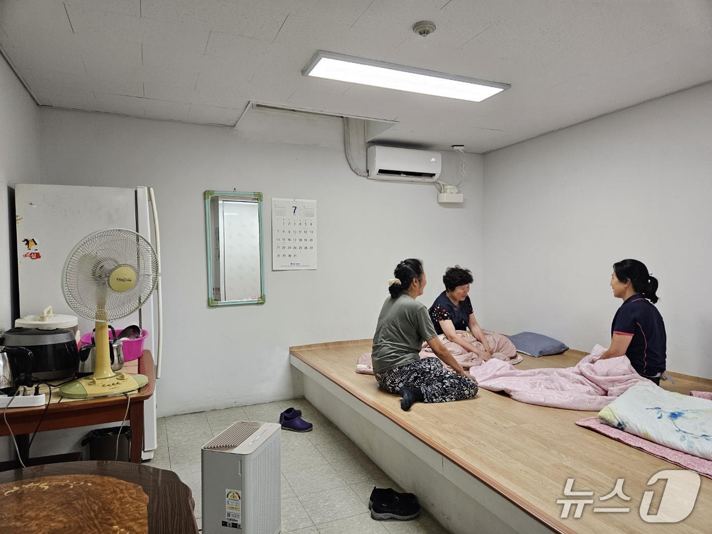 본문 이미지 - 성동구의 한 공동주택 미화원들이 에어컨이 설치된 휴게시설에서 휴식을 취하고 있는 모습 (성동구청 제공)