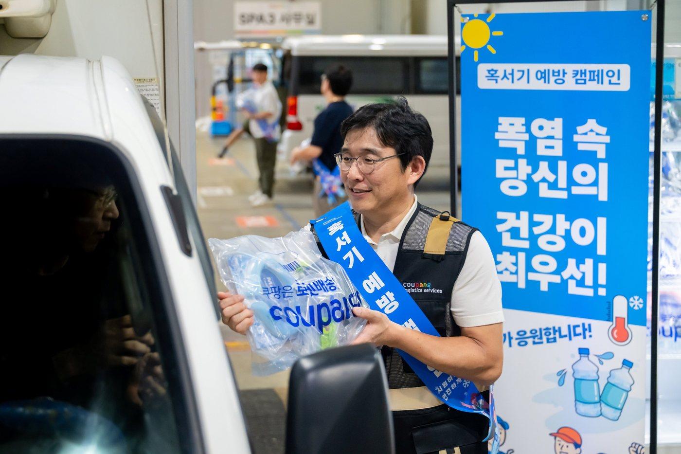  홍용준 CLS대표이사와 위탁배송업체 대표 등이 13일 오후 서울 송파 캠프에서 퀵플렉서들에게 온열질환 예방 물품을 지급하고 있다.(쿠팡로지스틱스서비스 제공).