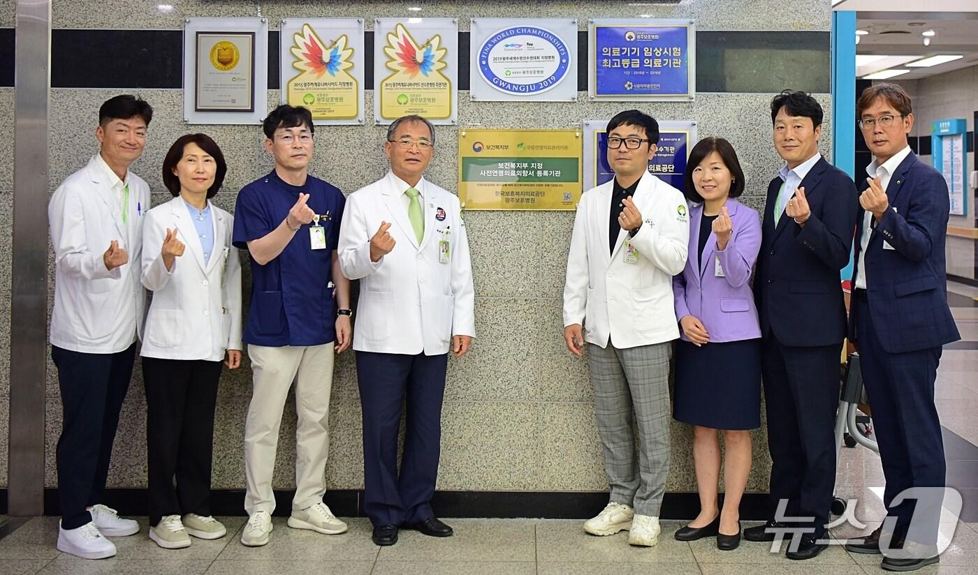 광주보훈병원 의료진이 '사전연명의료의향서 등록기관' 현판 앞에서 기념사진을 촬영하고 있다.(광주보훈병원 제공)