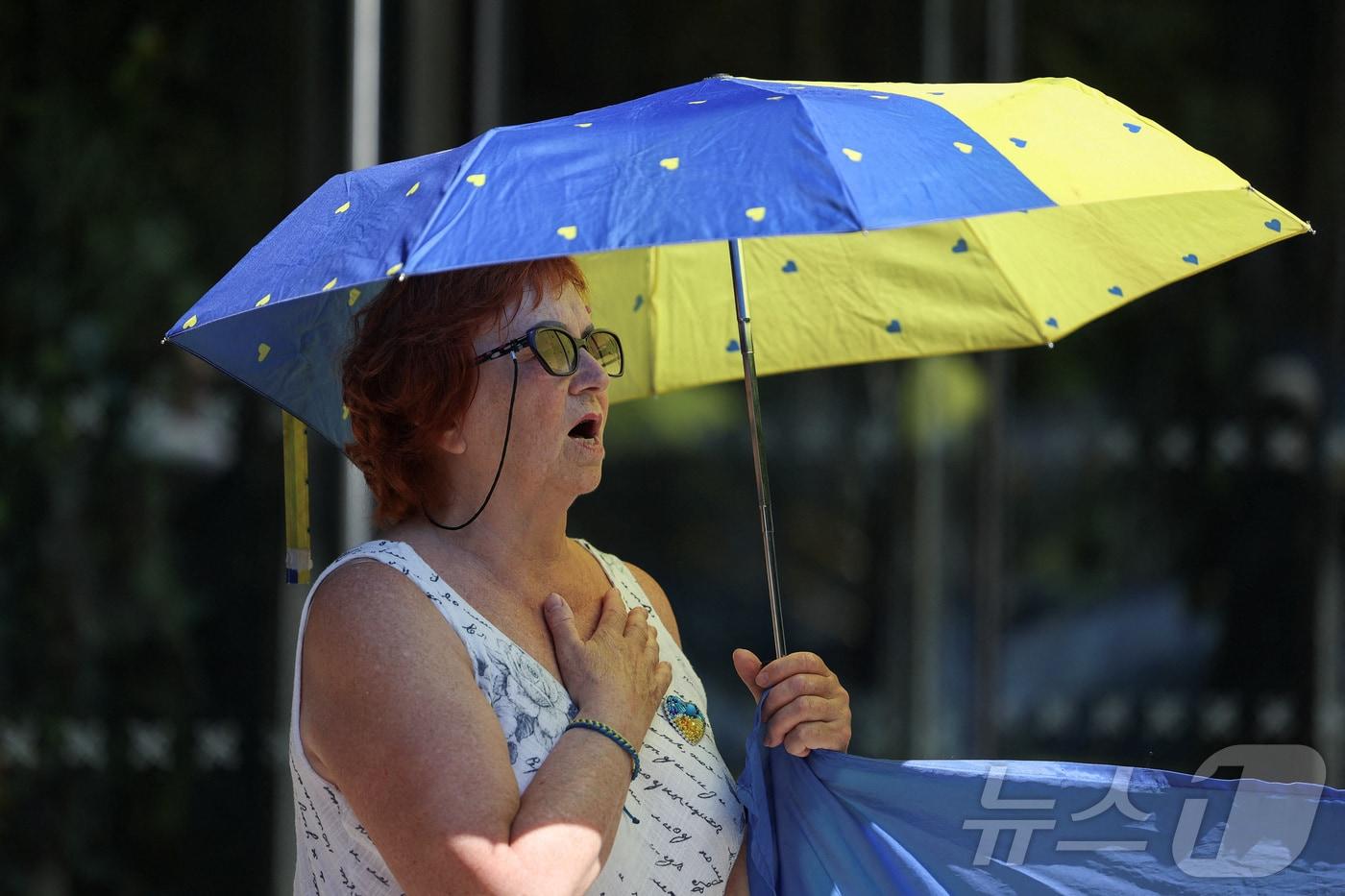 영국 맨체스터에서 한 여성이 햇볕을 피하기 위해 우산을 쓰고 있다. 2025.07.13 ⓒ 로이터=뉴스1 ⓒ News1 유채연 기자 &lt;자료사진&gt;