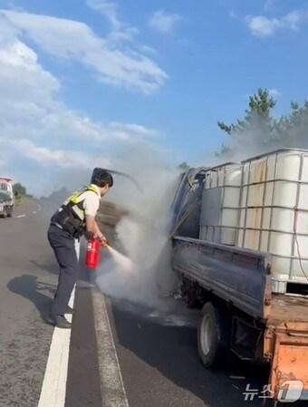 본문 이미지 - 지난 14일 오후 서귀포시 한 도로 위 1톤 트럭에서 불이 나 제주자치경찰단이 소화기로 진압하고 있다.(제주자치경찰단 제공. 재판매 및 DB 금지)