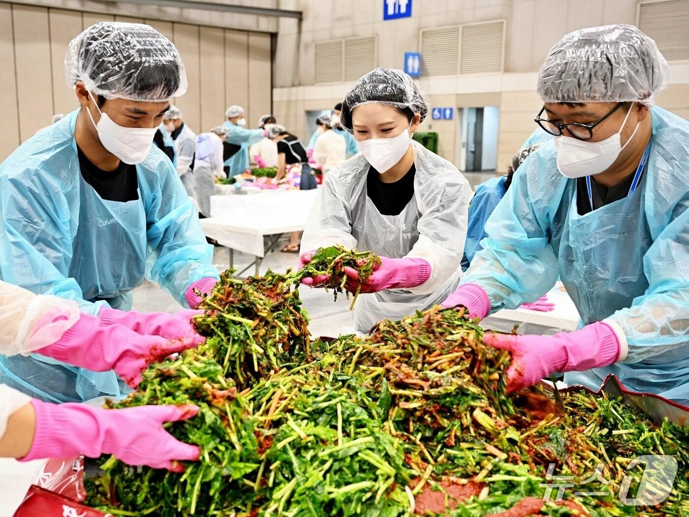 본문 이미지 - 지난 14일 킨텍스에서 열린 '2025 사랑의 열무김치 나눔행사'에서 킨텍스 직원과 자원봉사자들이 김치를 담그고 있다. (킨텍스 제공, 재판매 및 DB금지)