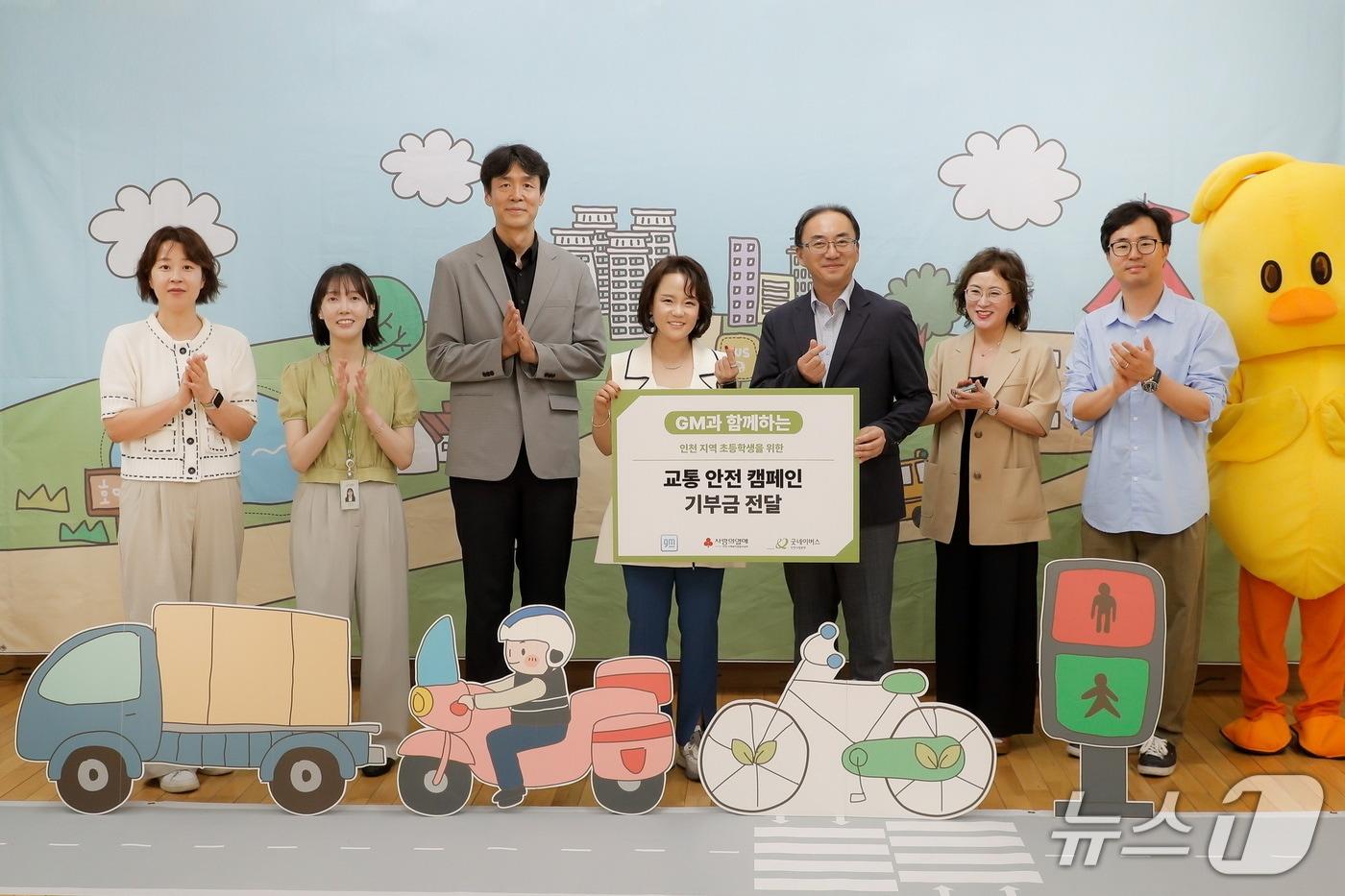 한국GM과 함께하는 인천 지역 초등학생을 위한 '교통 안전 캠페인' 전달식에서 기념 사진을 촬영하고 있는 윤명옥 GM 한국사업장 최고마케팅책임자(CMO) 겸 커뮤니케이션 총괄 전무(왼쪽에서 네번째), 홍상진 굿네이버스 인천사업본부 본부장(왼쪽에서 세번째), 이지훈 명선초등학교 교장(왼쪽에서 다섯번째) (한국GM 제공)