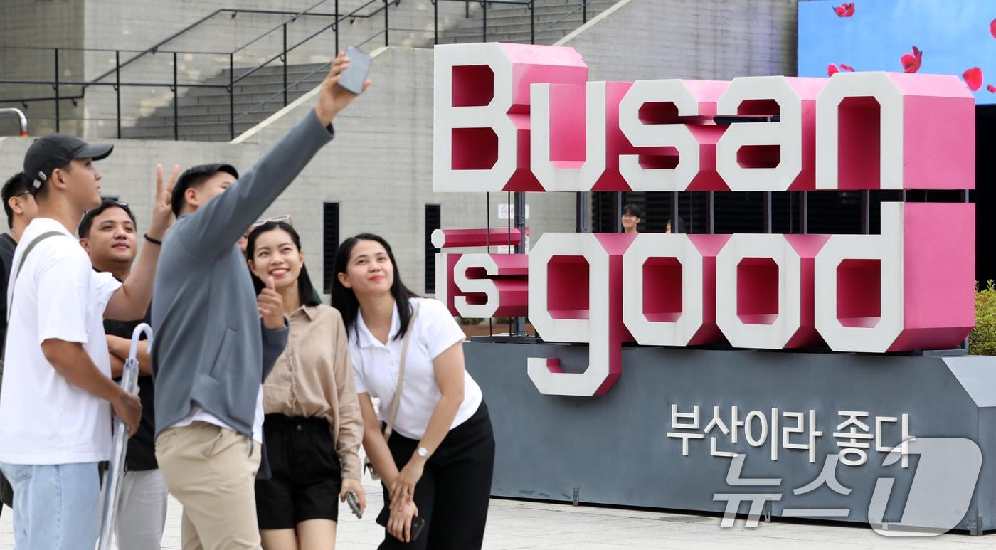 본문 이미지 - 부산 동구 부산역 광장에 있는 부산시 슬로건인 'Busan is good' 조형물 앞에서 외국인들이 기념촬영을 하고 있다. 2025.7.16 ⓒ 뉴스1 윤일지 기자