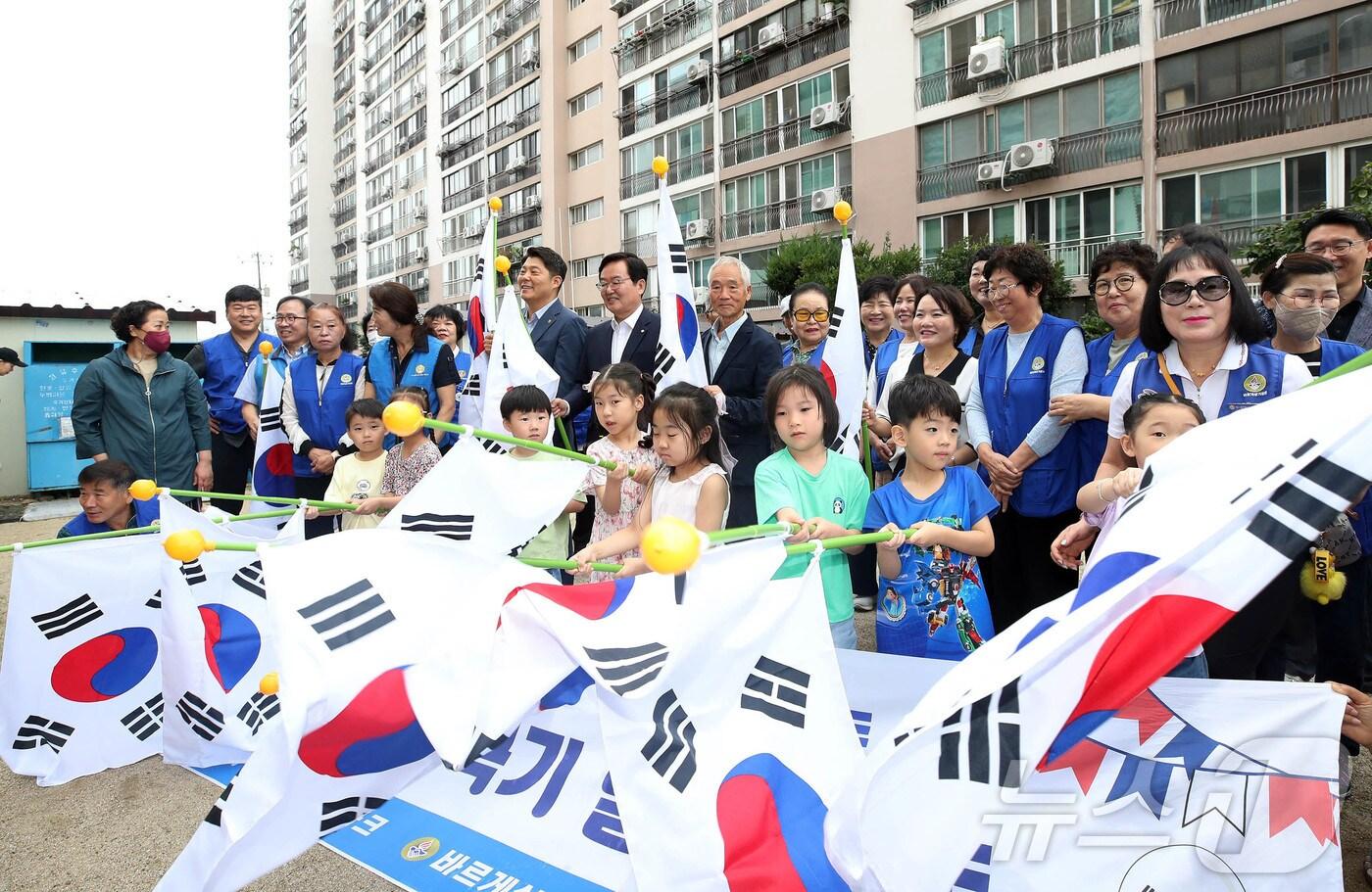 제헌절을 하루 앞둔 16일 광주 북구 신안동 중흥파크에서 열린 태극기 마을 조성 행사에서 문인 북구청장과 바르게살기운동북구협의회가 주민들에게 태극기 250개를 전달하고 아이들과 함께 태극기 퍼포먼스를 펼치고 있다.&#40;광주 북구 제공. 재판매 및 DB 금지&#41; 2025.7.16/뉴스1 ⓒ News1 박지현 기자