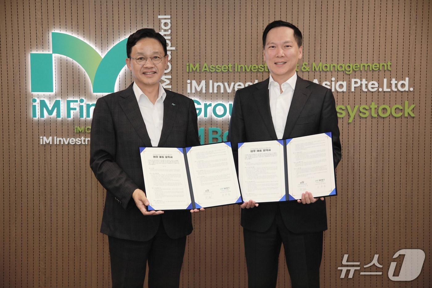 강정훈 iM뱅크 경영기획그룹장(왼쪽)과 김지강 한국씨티은행 소비자금융그룹장이 고객 편의 제고를 위한 업무 제휴 협약을 체결한 뒤 협약서를 펼쳐 보이고 있다.(iM뱅크 제공. 재판매 및 DB 금지)