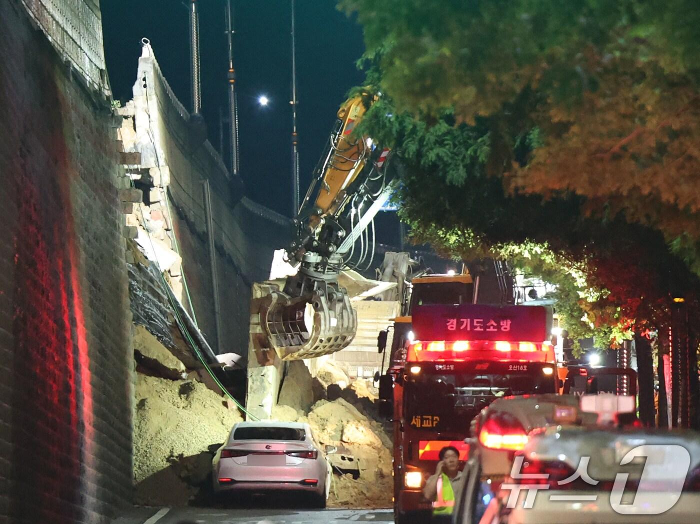 본문 이미지 - 16일 오후 경기 오산시 가장교차로 고가도로 옹벽이 무너져 소방관들이 매몰된 차량구조작업을 하고 있다. 2025.7.16/뉴스1 ⓒ News1 김영운 기자