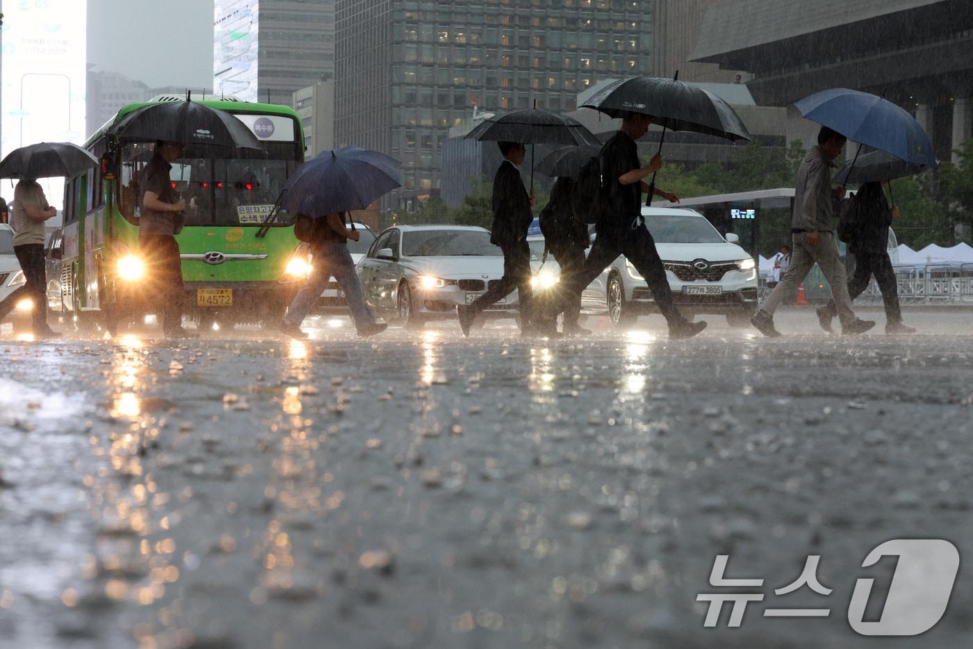 전국에 강한 비가 내린 17일 오전 서울 광화문광장에서 시민들이 물 고인 도로를 지나고 있다. 2025.7.17/뉴스1 ⓒ News1 신웅수 기자