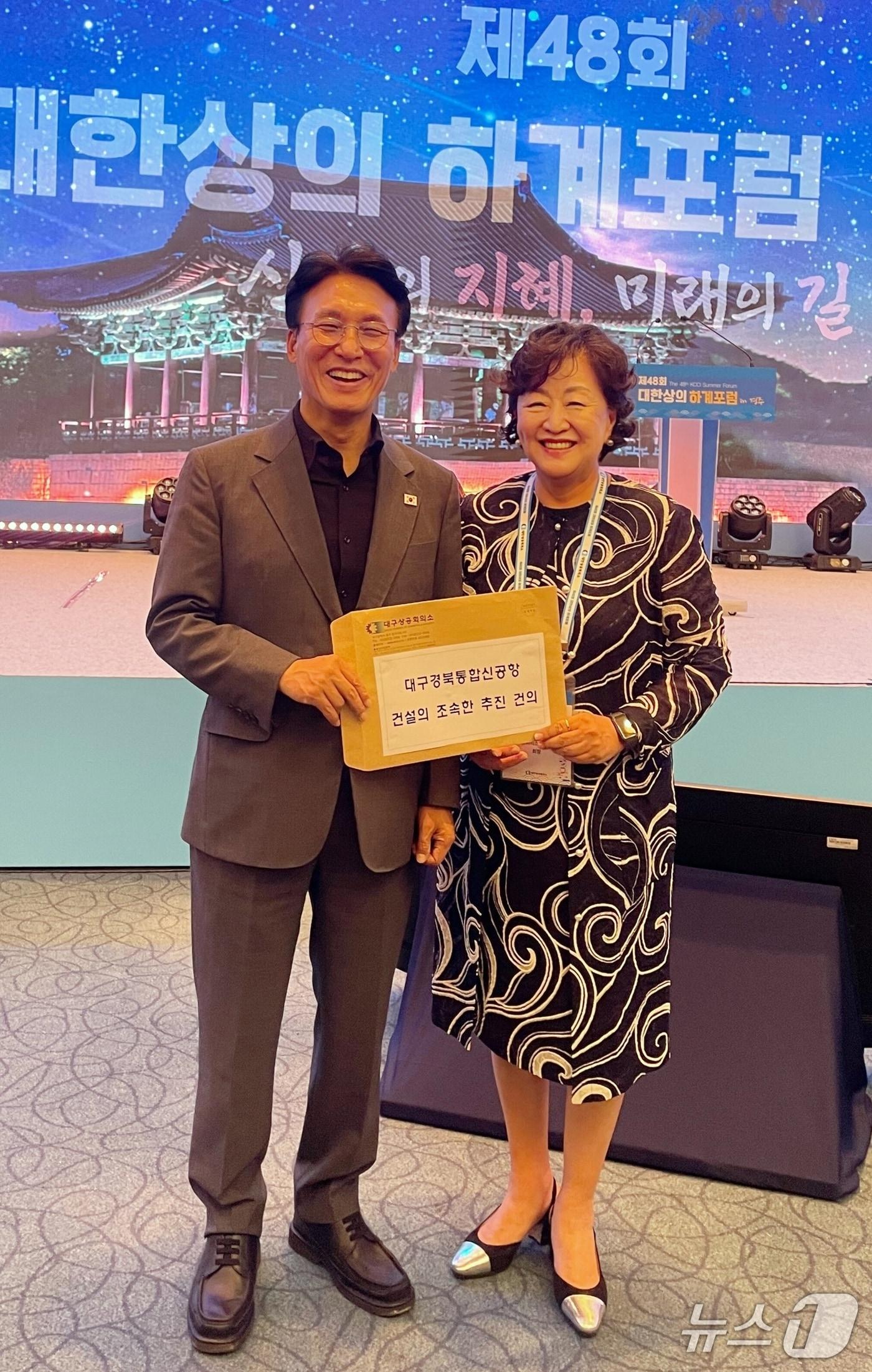 본문 이미지 - 라한셀렉트 경주 호텔에서 열린 대한상의 하계포럼에 참석한 박윤경 대구상공회의소 회장(오른쪽)이 김민석 국무총리에게 대구·경북 신공항 조속 건설을 위한 건의서를 전달하고 있다.(대구상의 제공. 재판매 및 DB 금지)