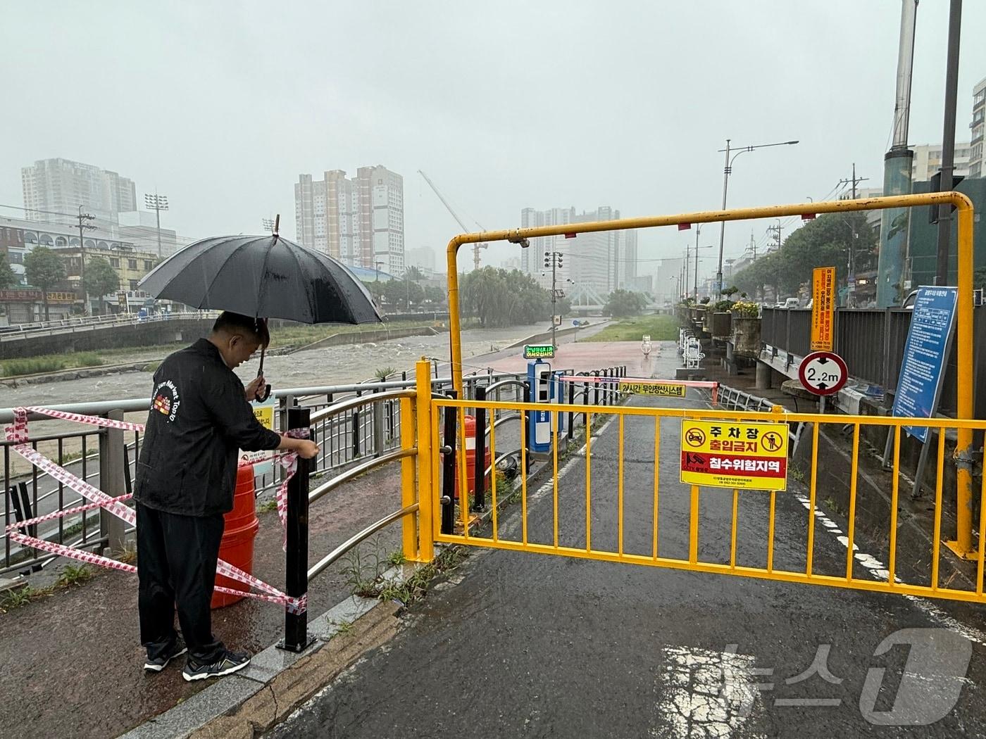 본문 이미지 - 17일 오전 광주에 호우경보가 발령된 가운데 도심을 가로지르는 광주천의 수위도 빠른 속도로 상승하면서 둔치주차장을 통제하고 있다. 2025.7.17/뉴스1 ⓒ News1 김태성 기자