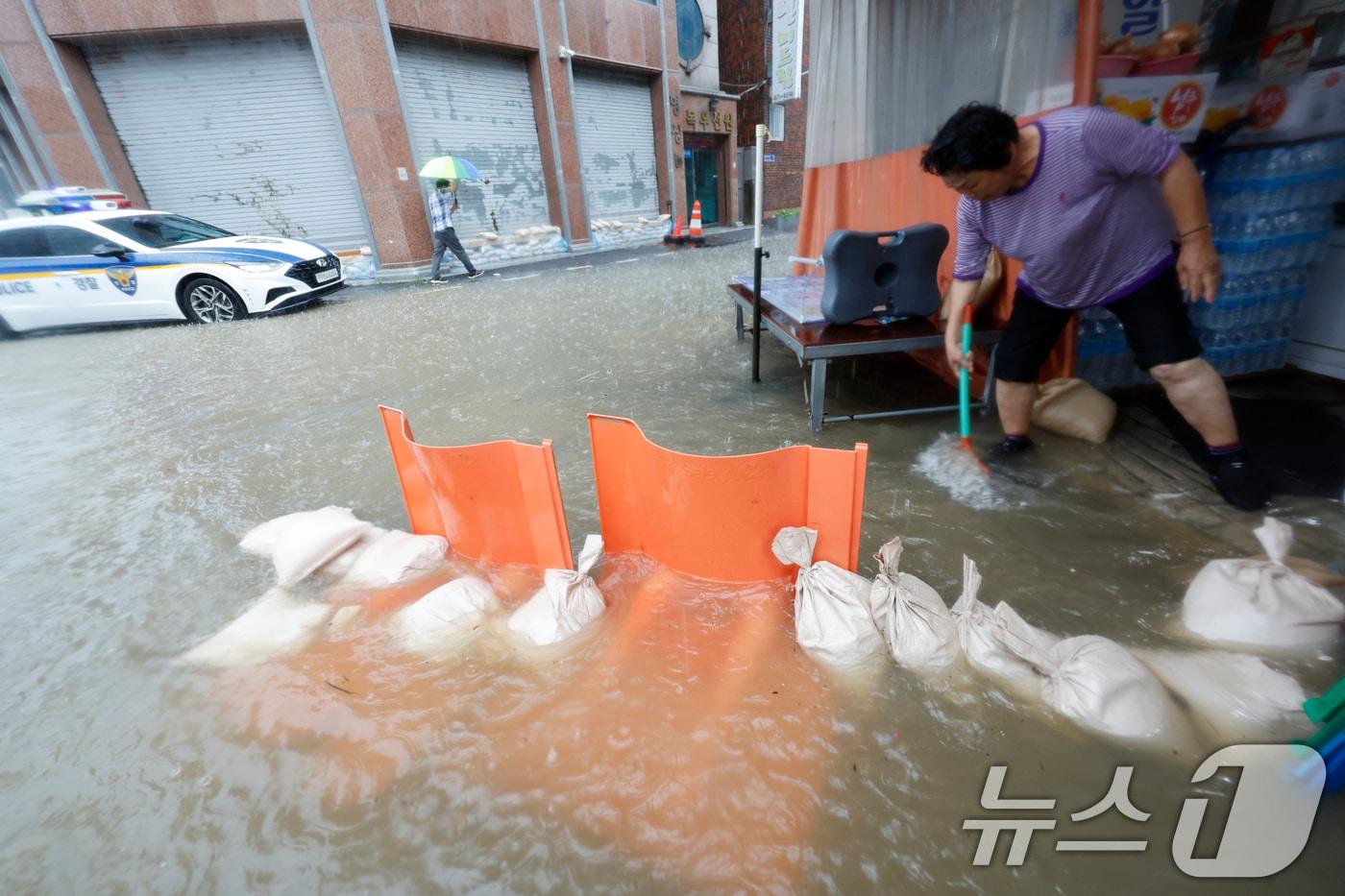호우경보가 발효된 17일 광주 남구 백운동 일대의 상가가 침수돼 주인이 가게앞 빗물을 쓸어내고 있다. 2025.7.17/뉴스1 ⓒ News1 김태성 기자