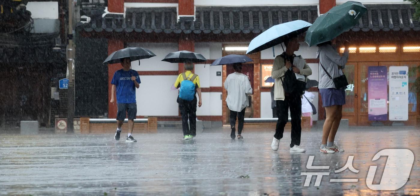 전북 전 지역에 호우특보 발효된 17일 전북 전주시 한옥마을 태조로에서 우산을 쓴 관광객들이 발걸음을 재촉하고 있다. 2025.7.17/뉴스1 ⓒ News1 유경석 기자