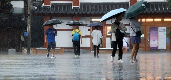 본문 이미지 - 전북 전 지역에 호우특보 발효된 17일 전북 전주시 한옥마을 태조로에서 우산을 쓴 관광객들이 발걸음을 재촉하고 있다. 2025.7.17/뉴스1 ⓒ News1 유경석 기자