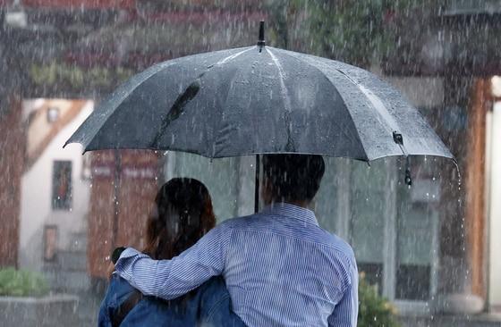 본문 이미지 - 전북 전 지역에 호우특보 발효된 17일 전북 전주시 한옥마을 경기전에서 우산을 쓴 관광객들이 발걸음을 재촉하고 있다. 2025.7.17/뉴스1 ⓒ News1 유경석 기자