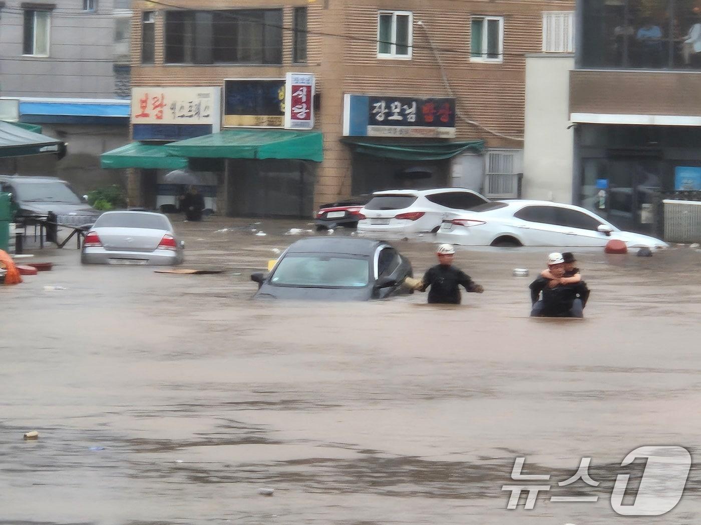 본문 이미지 - 17일 대구 북구 노곡동 일대가 침수돼 상가와 차량이 물이 잠겼다. 주민이 물길을 헤치고 걸어가고 있다.(독자 제공.재판매 및 DB금지) 2025.7.17/뉴스1 ⓒ News1 신성훈 기자