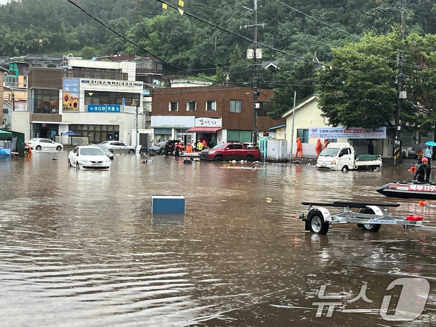본문 이미지 - 지난 17일 폭우로 대구 북구 노곡동 마을이 침수돼 상가와 차량이 물이 잠겼다. 물이 차오르자 주민들이 물길을 헤치며 걸어가고 있다.&#40;독자 제공.재판매 및 DB금지&#41; 2025.7.17/뉴스1 ⓒ News1 신성훈 기자