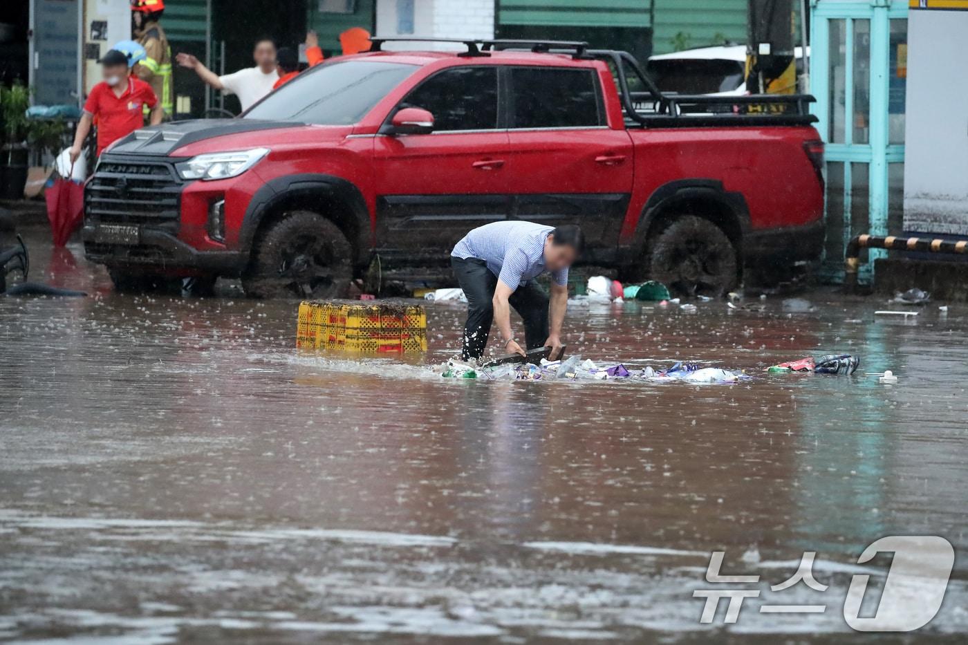 17일 오후 대구 북구 노곡동 마을이 집중호우에 침수돼 한 주민이 막힌 배수구를 뚫고 있다. 2025.7.17/뉴스1 ⓒ News1 공정식 기자