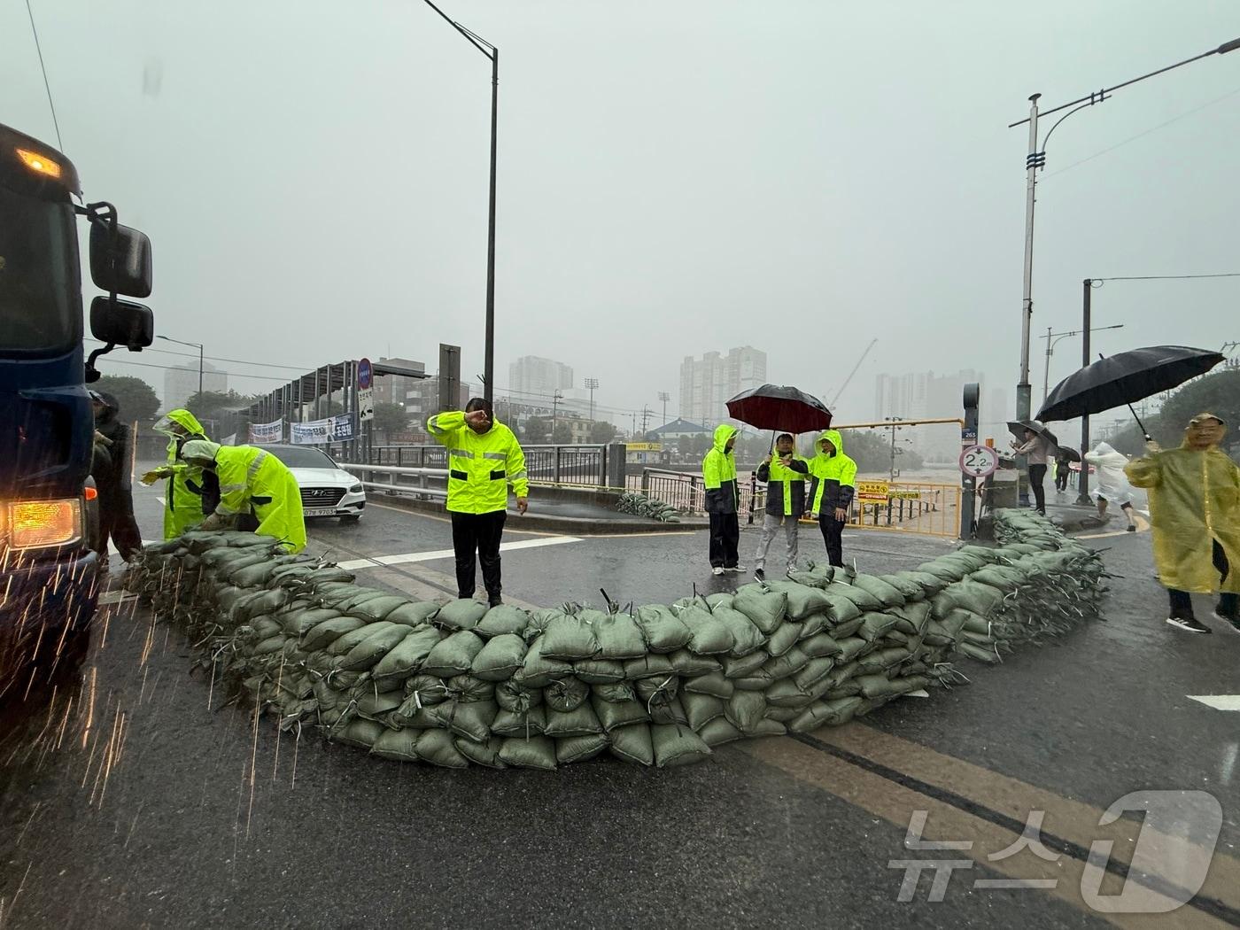 본문 이미지 - 지난 17일 오후 광주천을 가로지르는 태평교 범람 우려로 양동복개상가 앞 천변좌로에 모래 주머니가 쌓여있다. 2025.7.17/뉴스1 ⓒ News1 김태성 기자