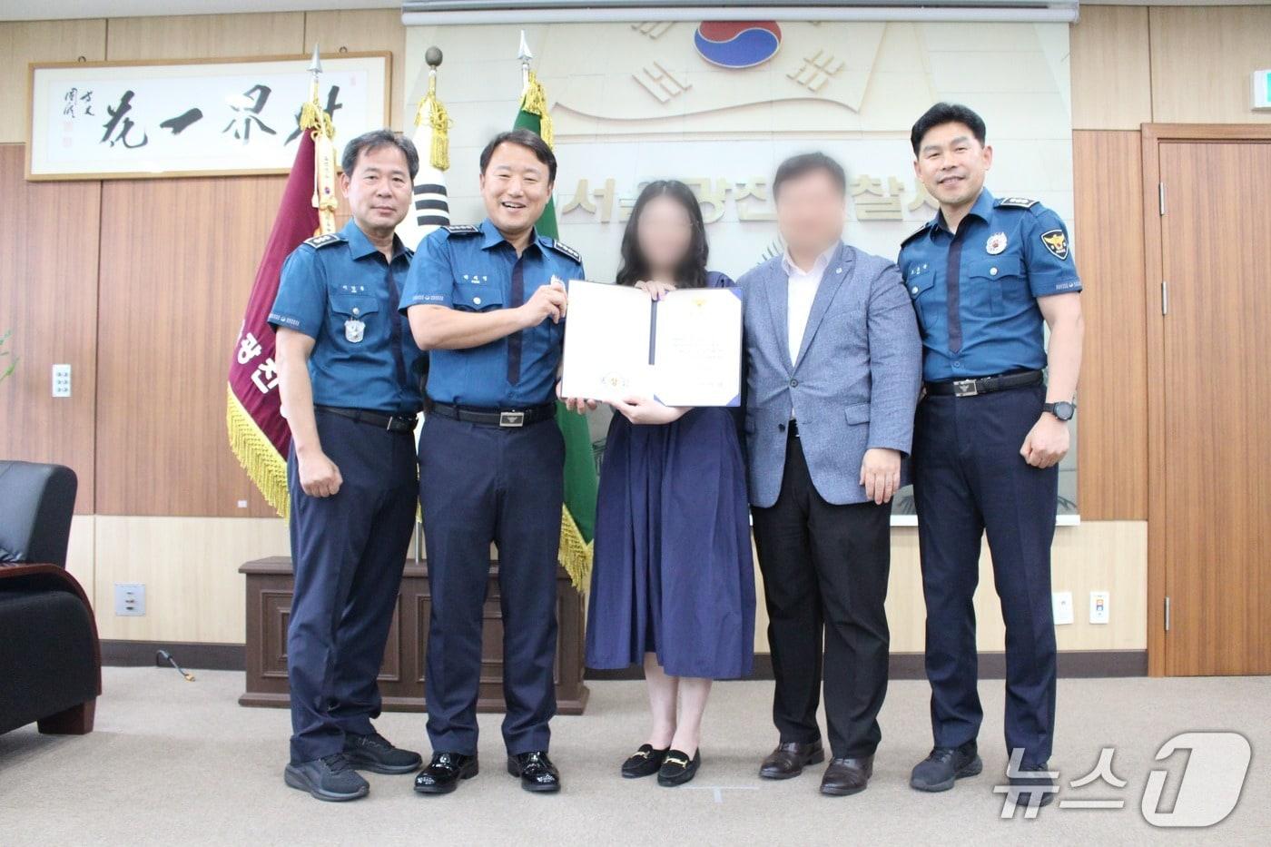 고객의 보이스피싱 피해를 막은 은행원 A 씨가 광진경찰서로부터 감사장을 받고 있다.&#40;광진경찰서 제공&#41;