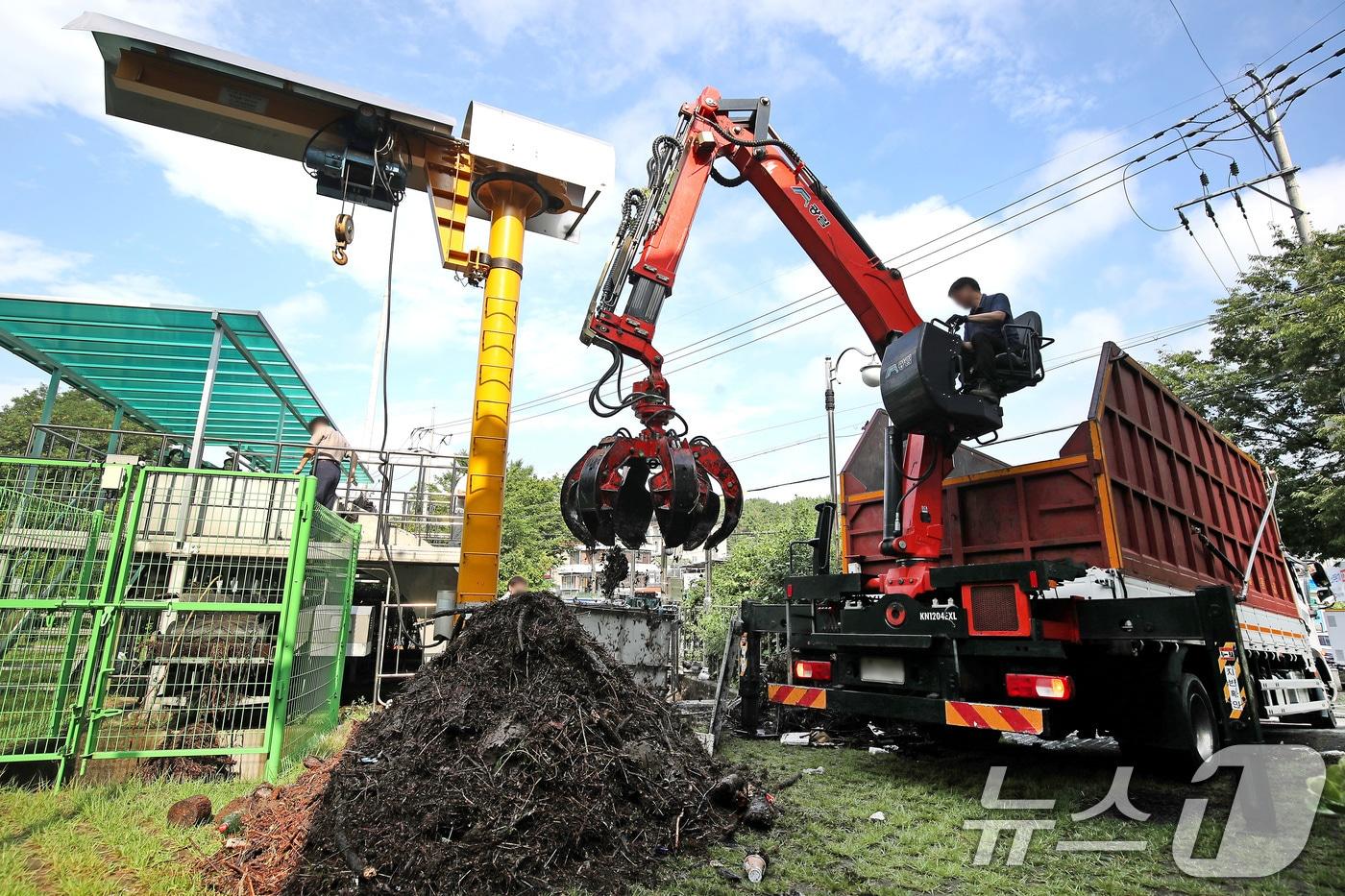 18일 오전 대구 북구 노곡동 빗물펌프장에서 시설 관계자들이 집게크레인을 동원해 전날 집중호우 때 쌓인 쓰레기와 나뭇가지 등 찌꺼기를 제거하고 있다. 2025.7.18/뉴스1 ⓒ News1 공정식 기자