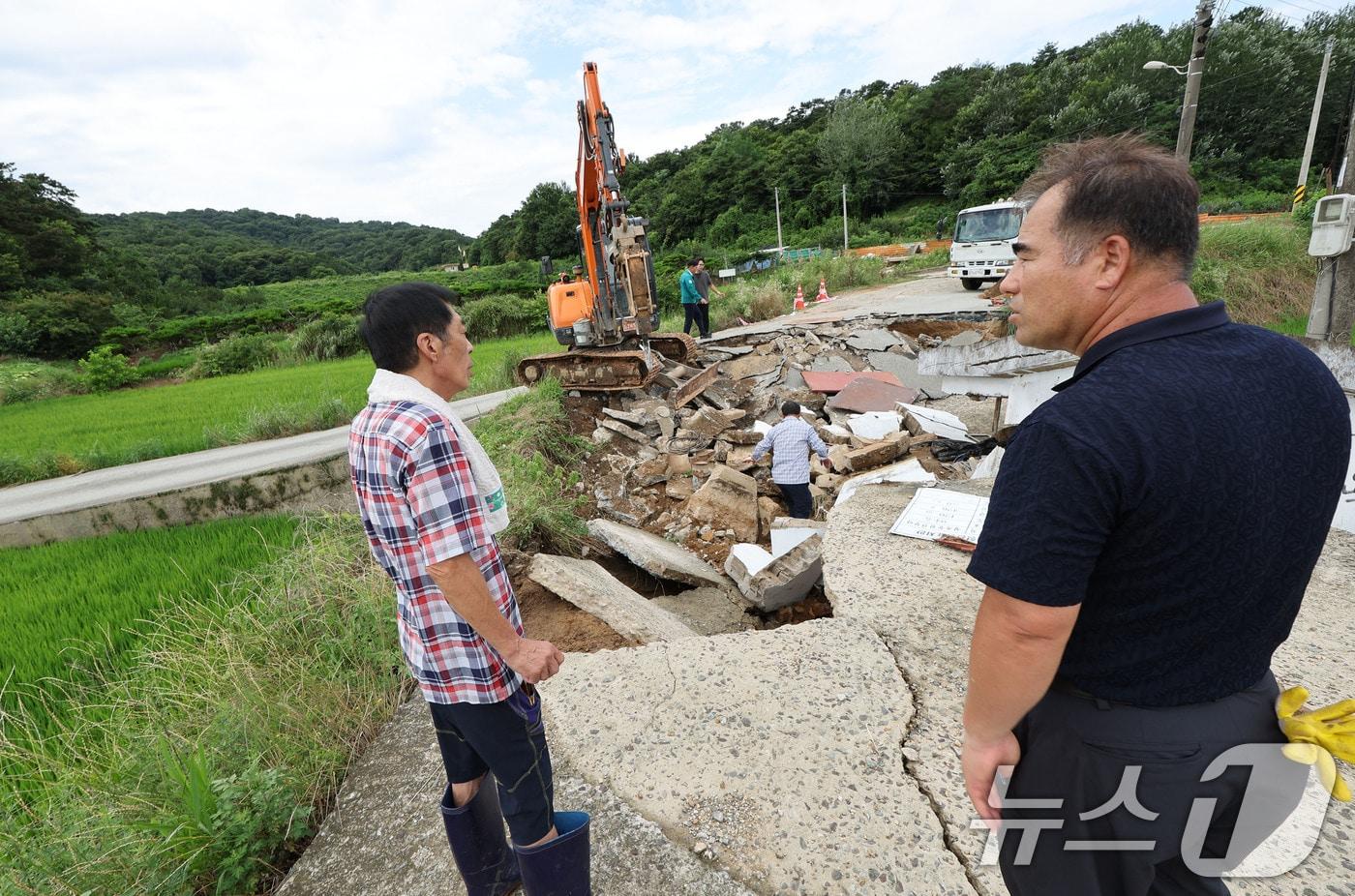 전날 내린 집중호우로 인해 18일 광주 북구 망월동에 위치한 대형관정이 붕괴되어 길이 끊겨 있다. 사진은 긴급복구 작업을 바라보는 주민의 모습. 2025.7.18/뉴스1 ⓒ News1 박지현 기자