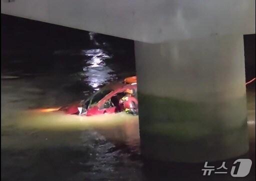 본문 이미지 - 18일 오후 11시 20분쯤 하동군 고전면 고남교 인근 하천에 빠진 차량에서 소방대원이 운전자를 구조하고 있다.(경남소방본부 제공. 재판매 및 DB금지)