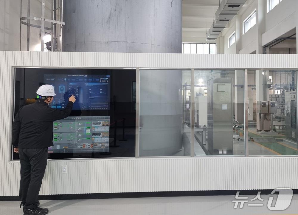 본문 이미지 - 한국수자원공사 관계자가 경기 화성에 있는 AI 정수장에서 약품주입동에 구현된 ‘스마트 미러’(터치형 화면)를 보며 정수처리에 필요한 약품주입 자율공정 현황 등을 살펴보고 있다. (한국수자원공사 제공. 재판매 및 DB금지)/뉴스1