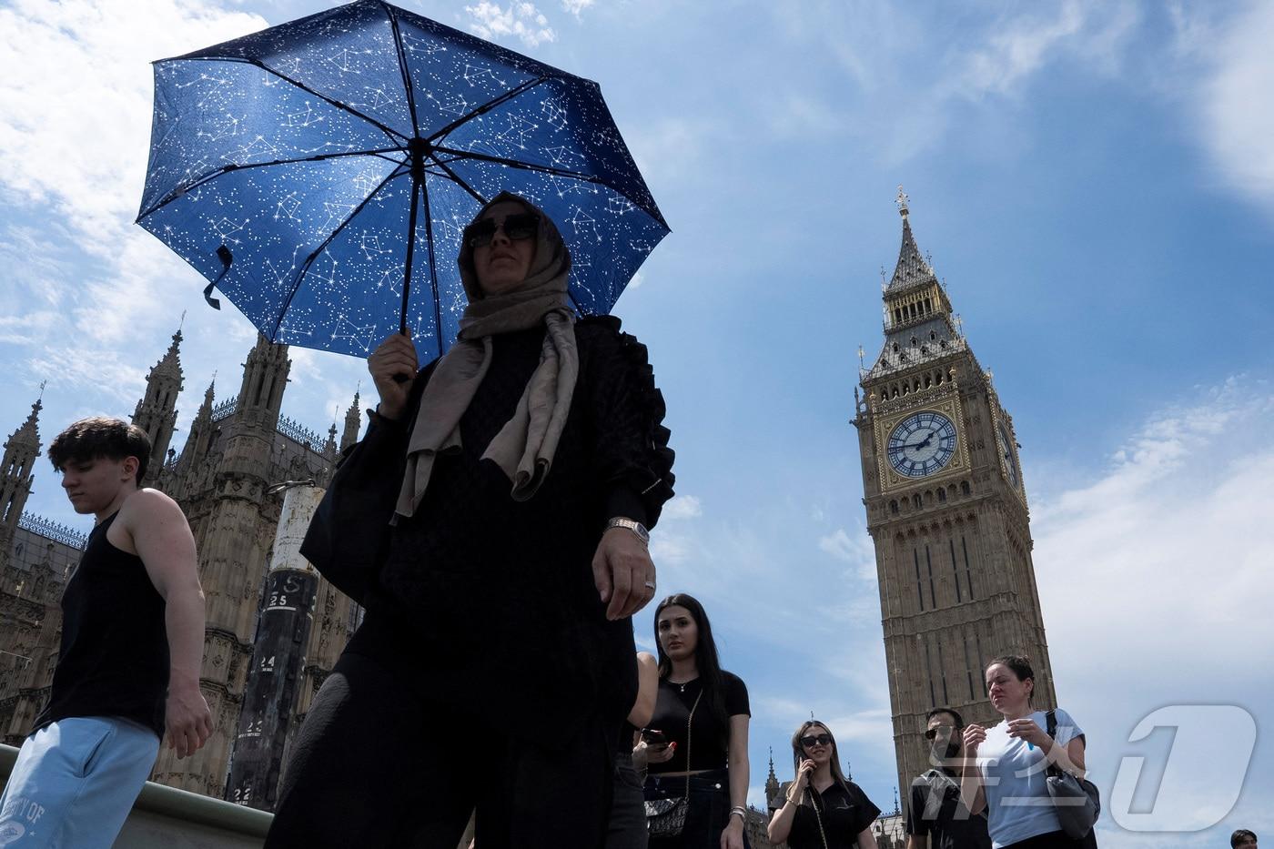1일&#40;현지시간&#41; 영국 런던의 빅벤 앞을 우산 쓴 여성이 지나가고 있다. 영국은 일부 지역 기온이 33.5도까지 오르며 연중 가장 더운 날을 기록했다. 2025.06.01. ⓒ 로이터=뉴스1 ⓒ News1 이지예 객원기자