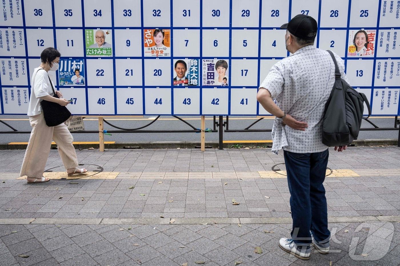 일본 도쿄의 한 행인이 3일 일본 참의원 선거 후보들의 포스터를 살펴보고 있다. 2025.7.3 ⓒ AFP=뉴스1 ⓒ News1 강민경 기자