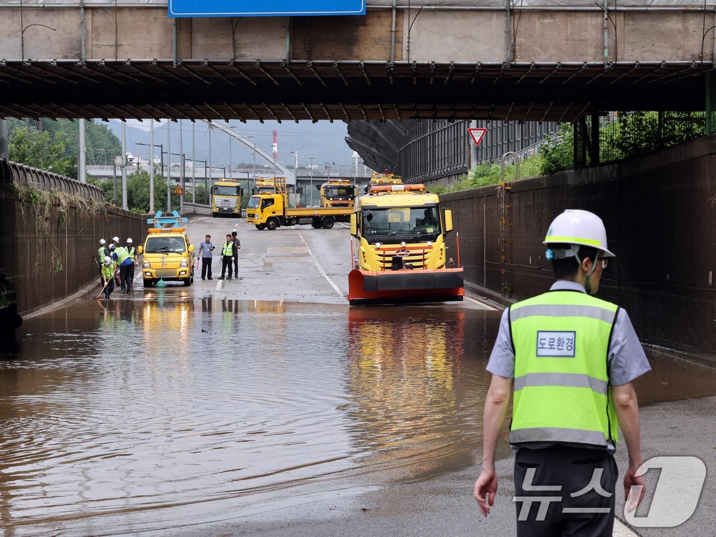 본문 이미지 - 집중 호우로 서울 중랑천 수위가 상승한서울 노원구 월계1교 인근 동부간선도로에서 서울시설관리공단 관계자들이 도로 정비작업을 하고 있다.  2025.7.20 ⓒ 뉴스1 황기선 기자