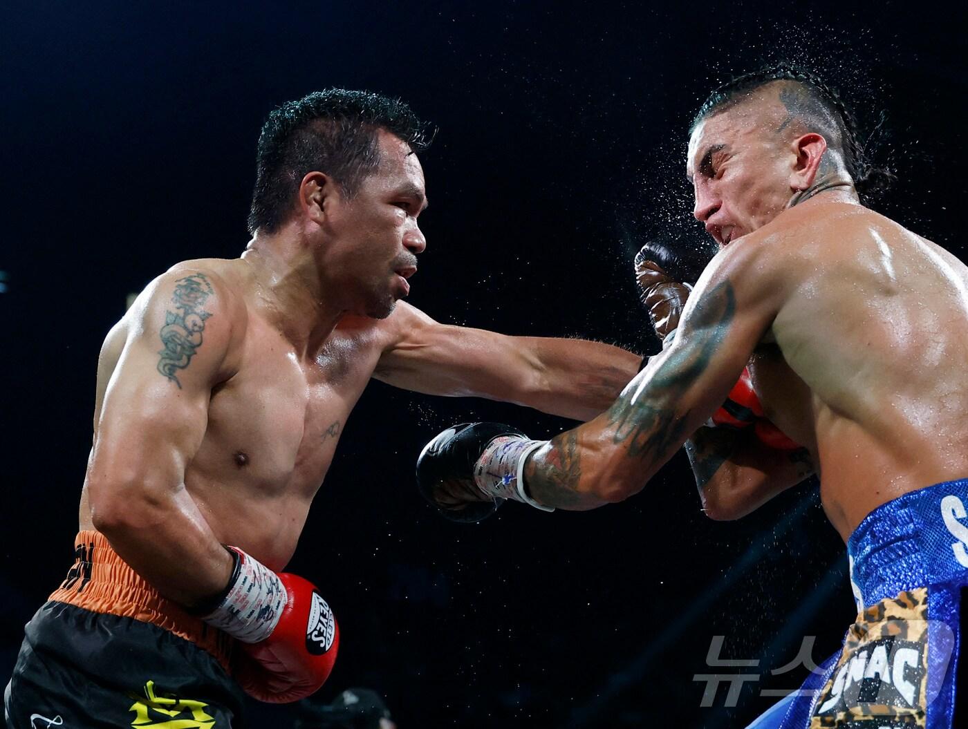 본문 이미지 - 파키아오(왼쪽)가 20일(한국시간) 미국 네바다주 라스베이거스의 MGM그랜드가든아레나에서 열린 WBC 웰터급 타이틀전에서 챔피언 바리오스와 경기하고 있다. ⓒ AFP=뉴스1