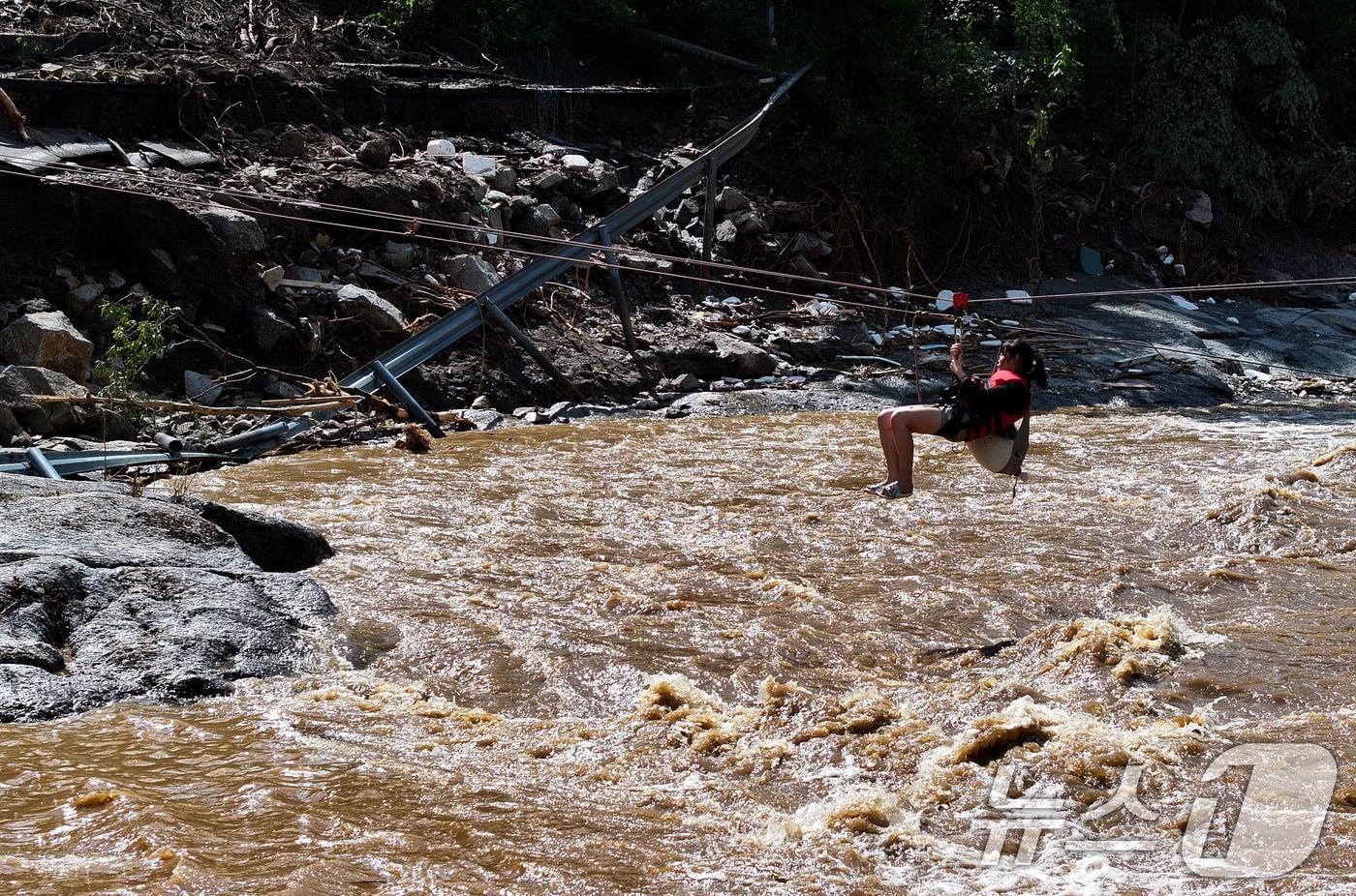 20일 경기 가평군 마일리의 한 캠핑장에 고립된 시민들이 소방 로프를 타고 탈출하고 있다. 2025.7.20/뉴스1 ⓒ News1 신웅수 기자