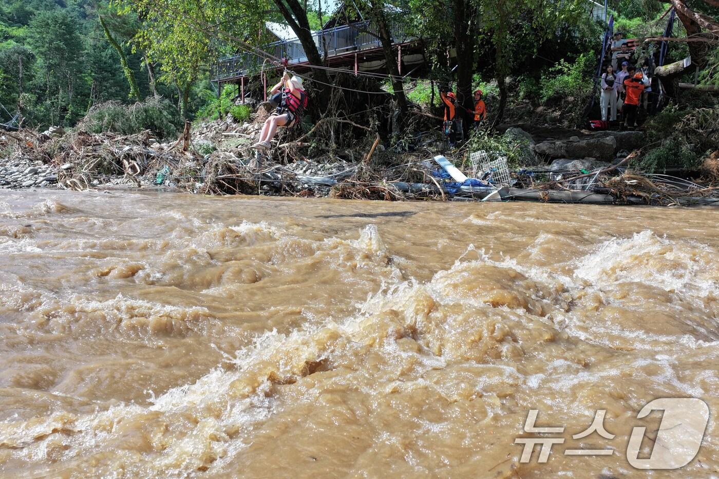 20일 경기 가평군 마일리의 한 캠핑장에 고립된 시민들이 소방 로프를 타고 탈출하고 있다. 2025.7.20/뉴스1 ⓒ News1 신웅수 기자